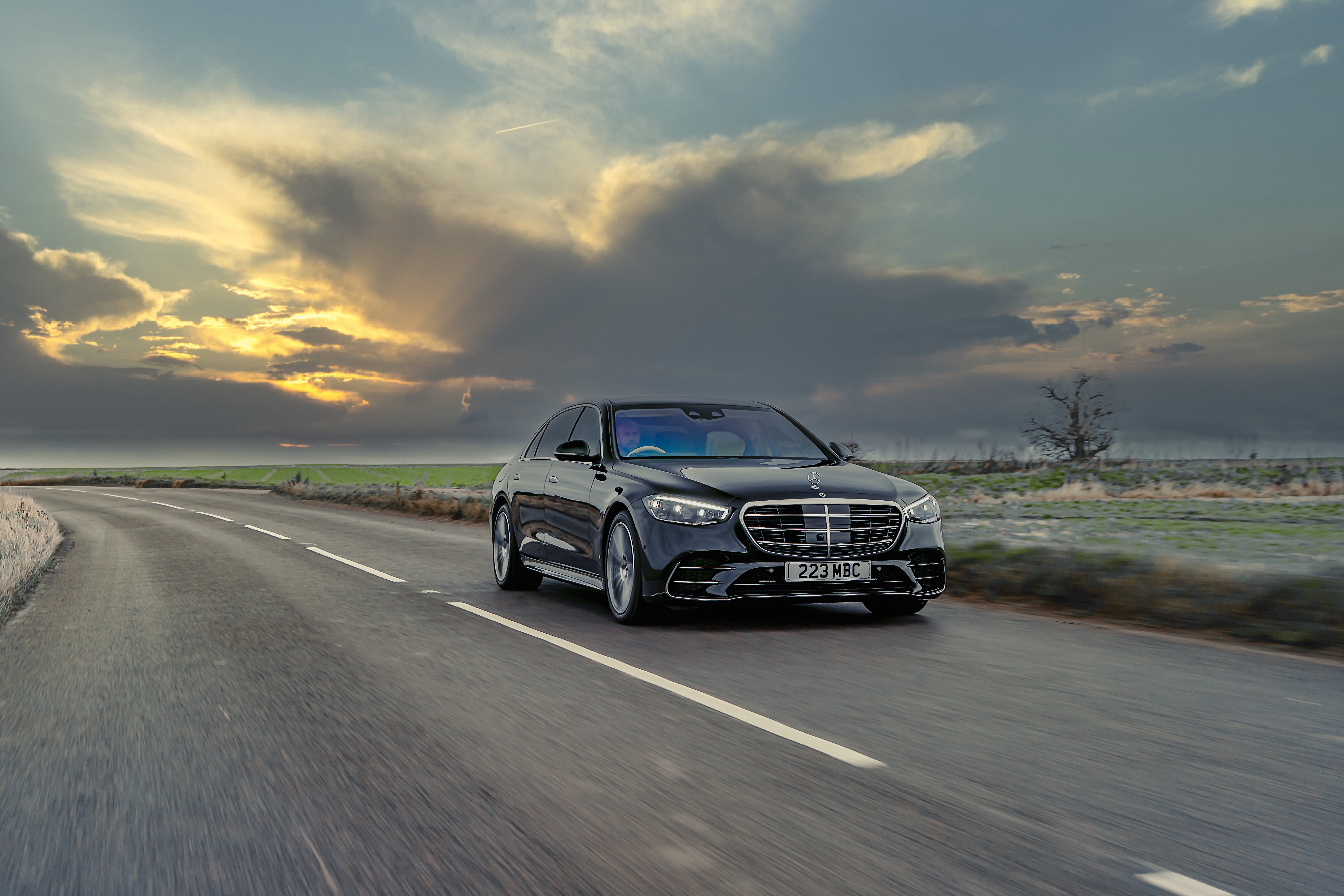Black Mercedes-Benz S-Class 580 driving on a road HD Wallpaper