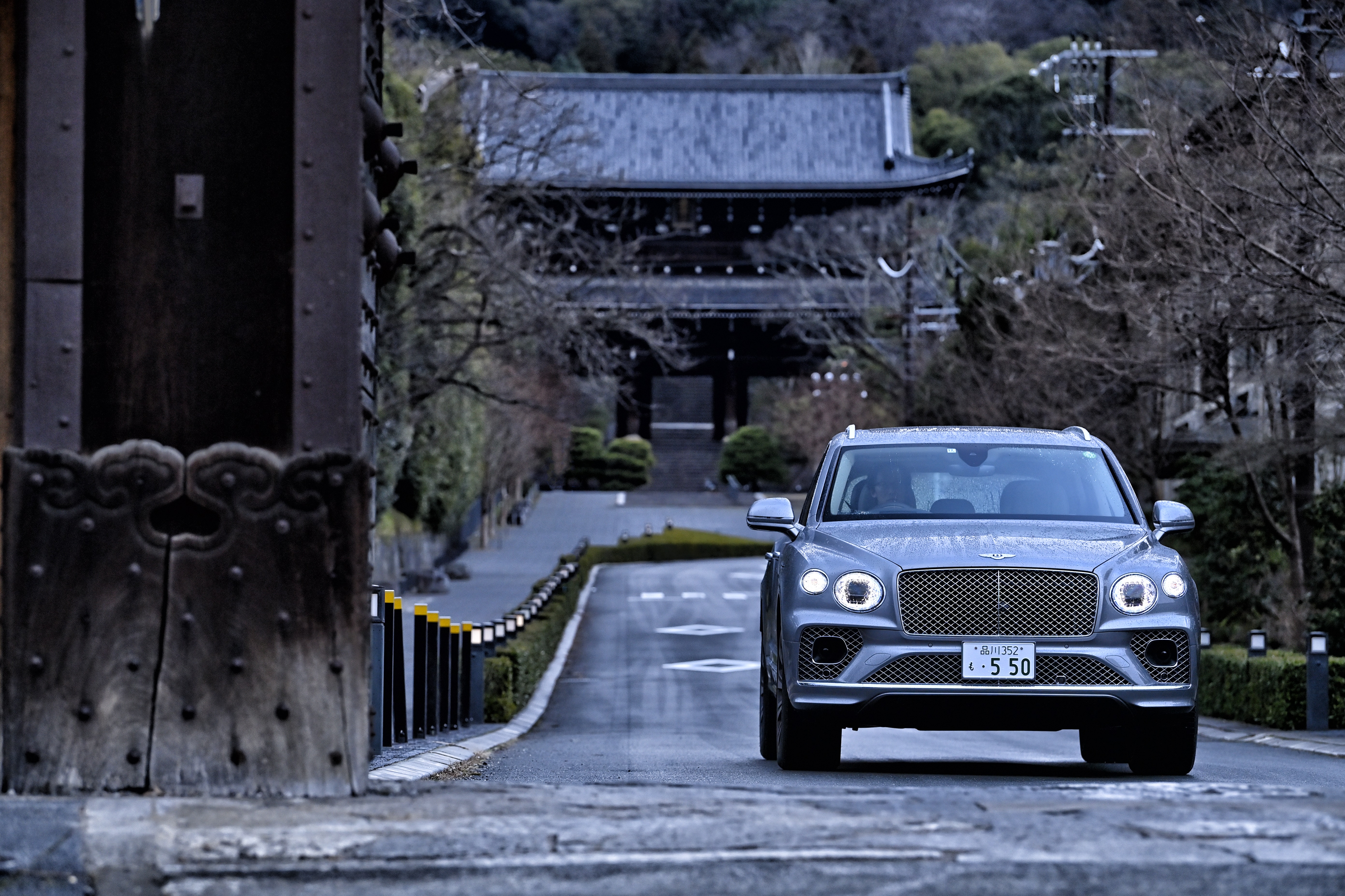 Bentley Bentayga SUV on a road in front of a temple HD Wallpaper