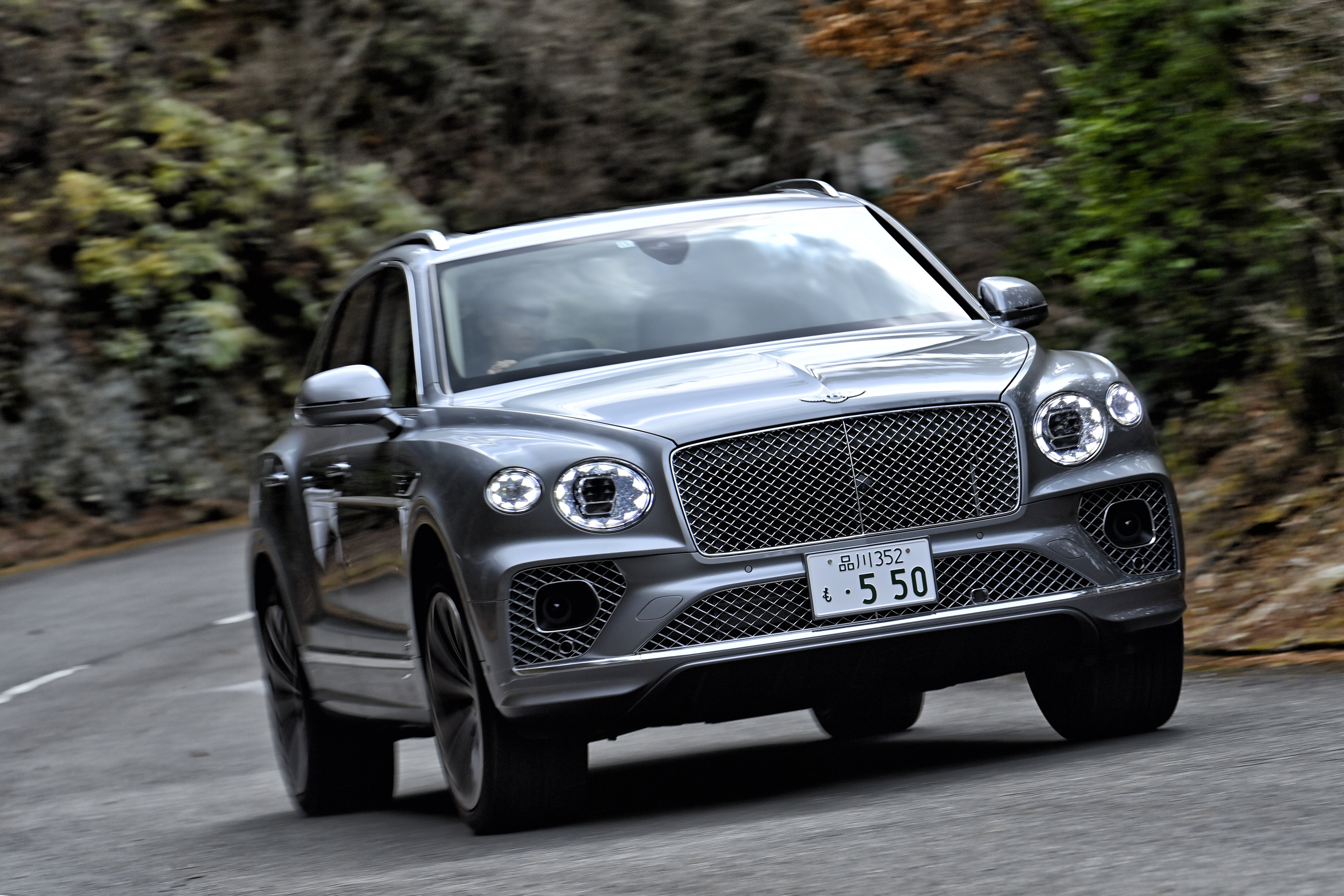 Bentley Bentayga V8 SUV driving on a winding road HD Wallpaper