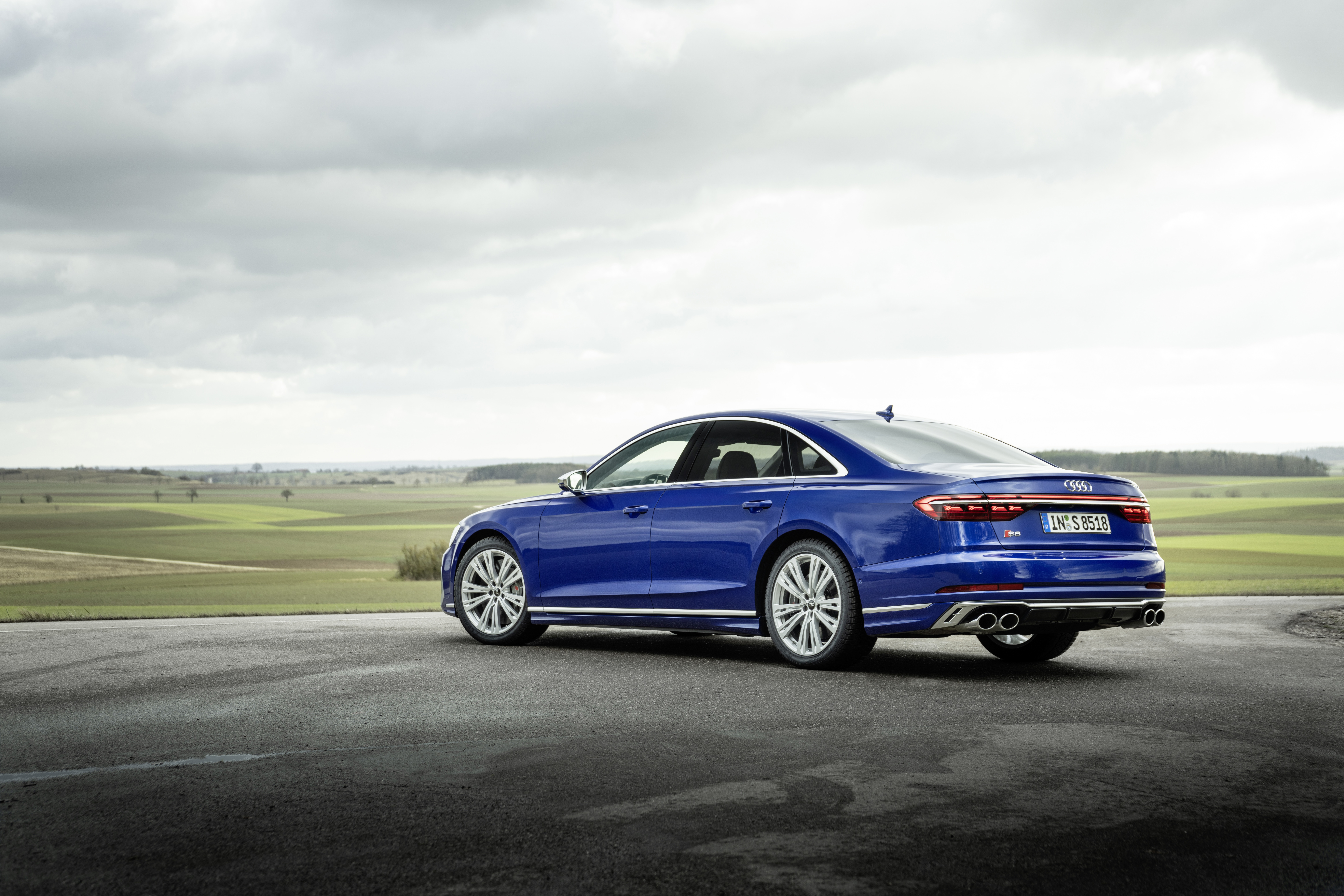 Blue Audi S8 parked on asphalt with fields in background HD Wallpaper