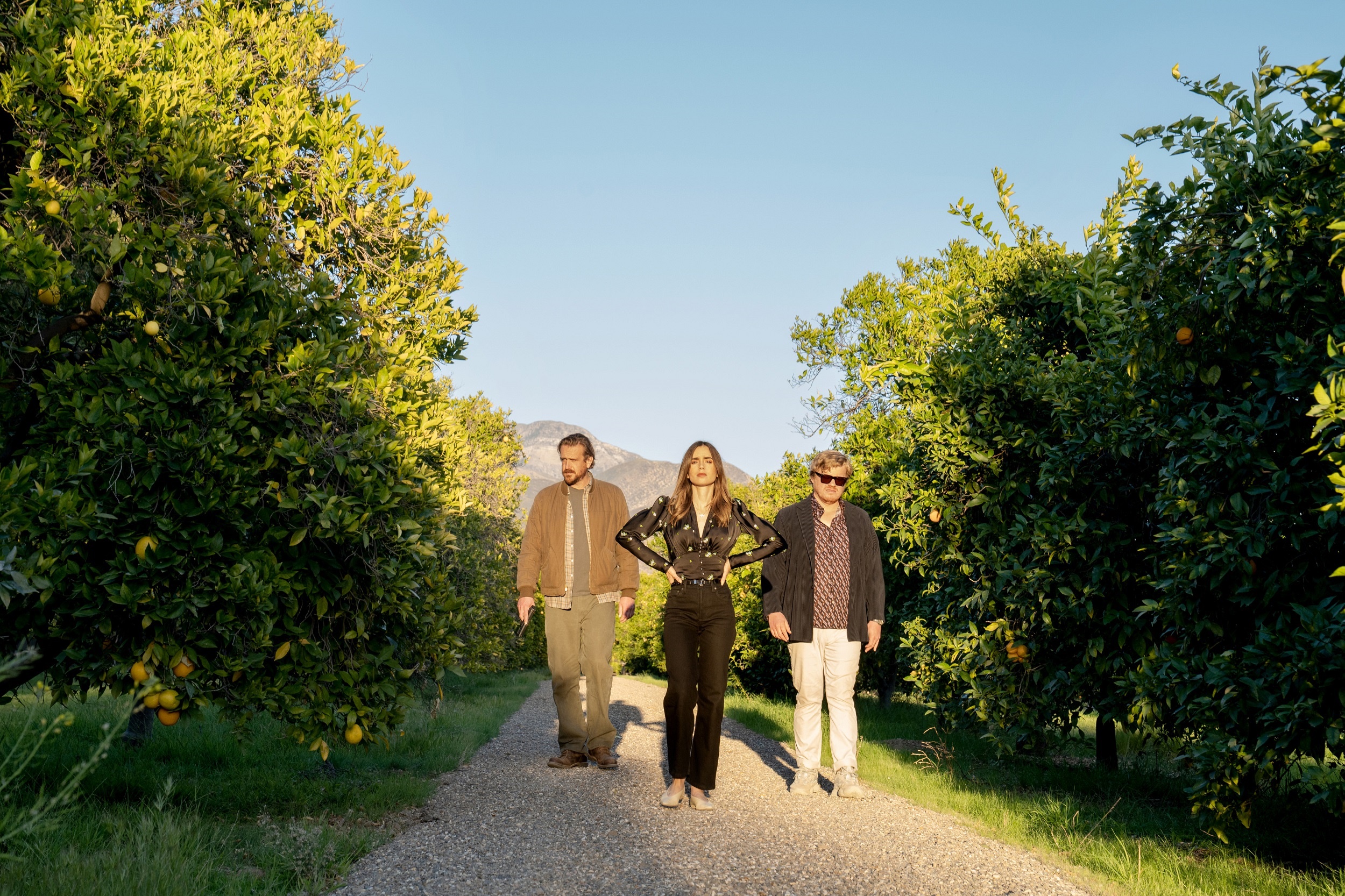 Lily Collins, Jason Segel, and Jesse Plemons in an orchard HD Wallpaper