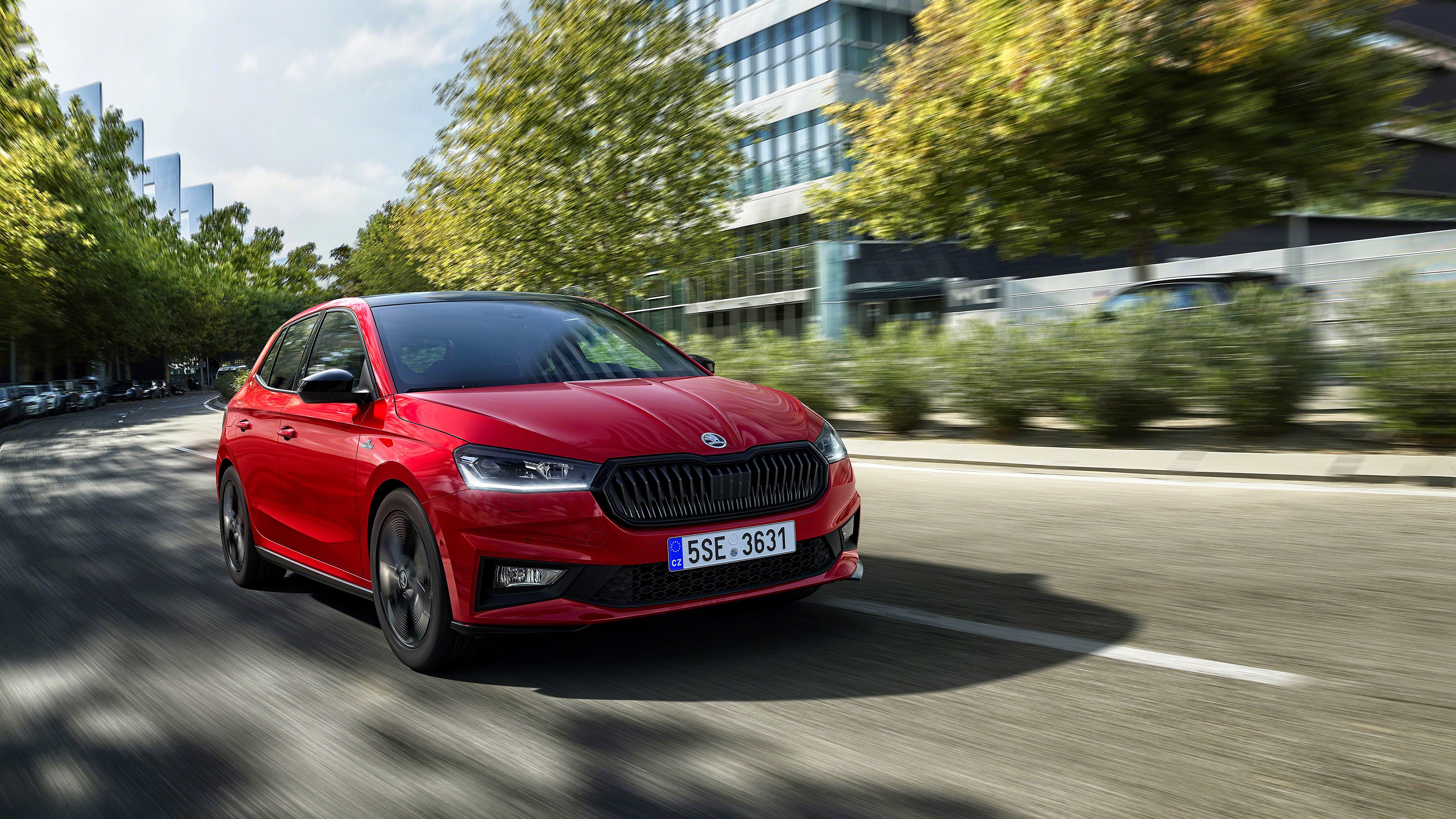 Red Skoda Fabia driving on a sunny day HD Wallpaper