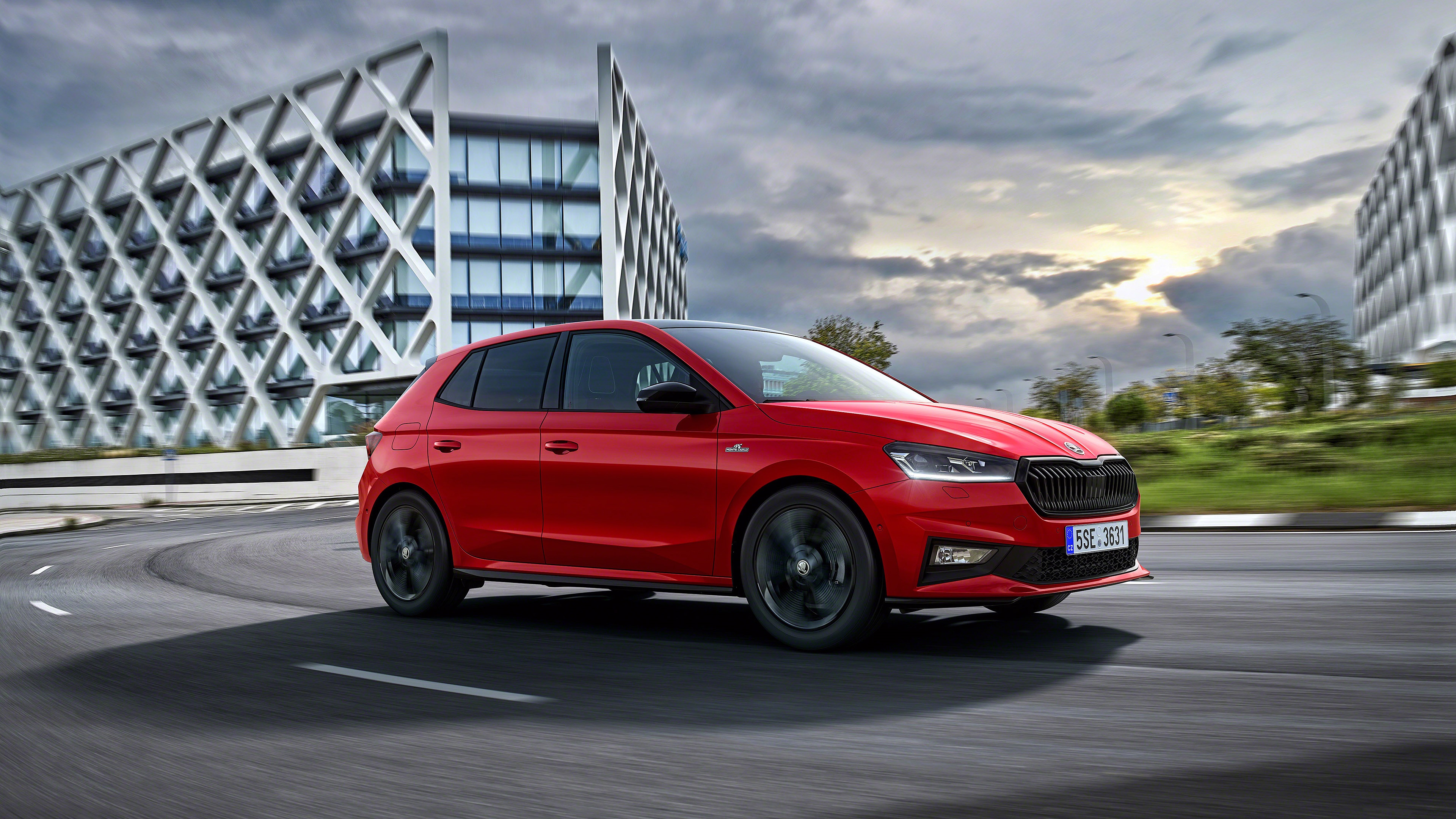Red Škoda Fabia driving on a road HD Wallpaper