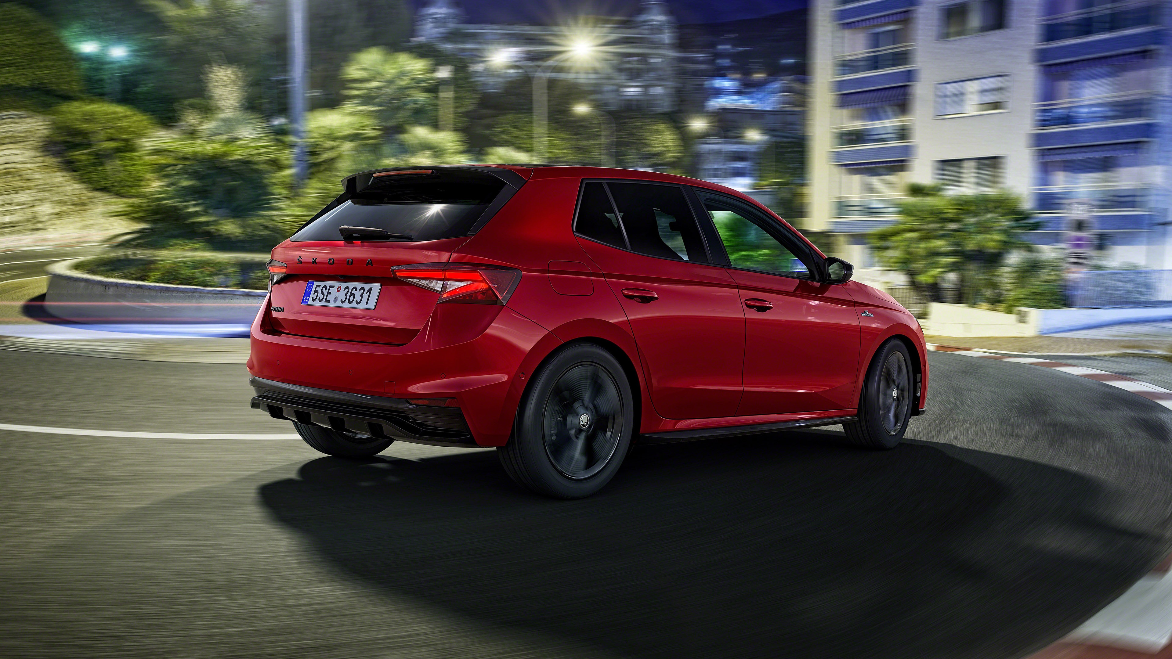Red Skoda Fabia driving on a city street at night HD Wallpaper
