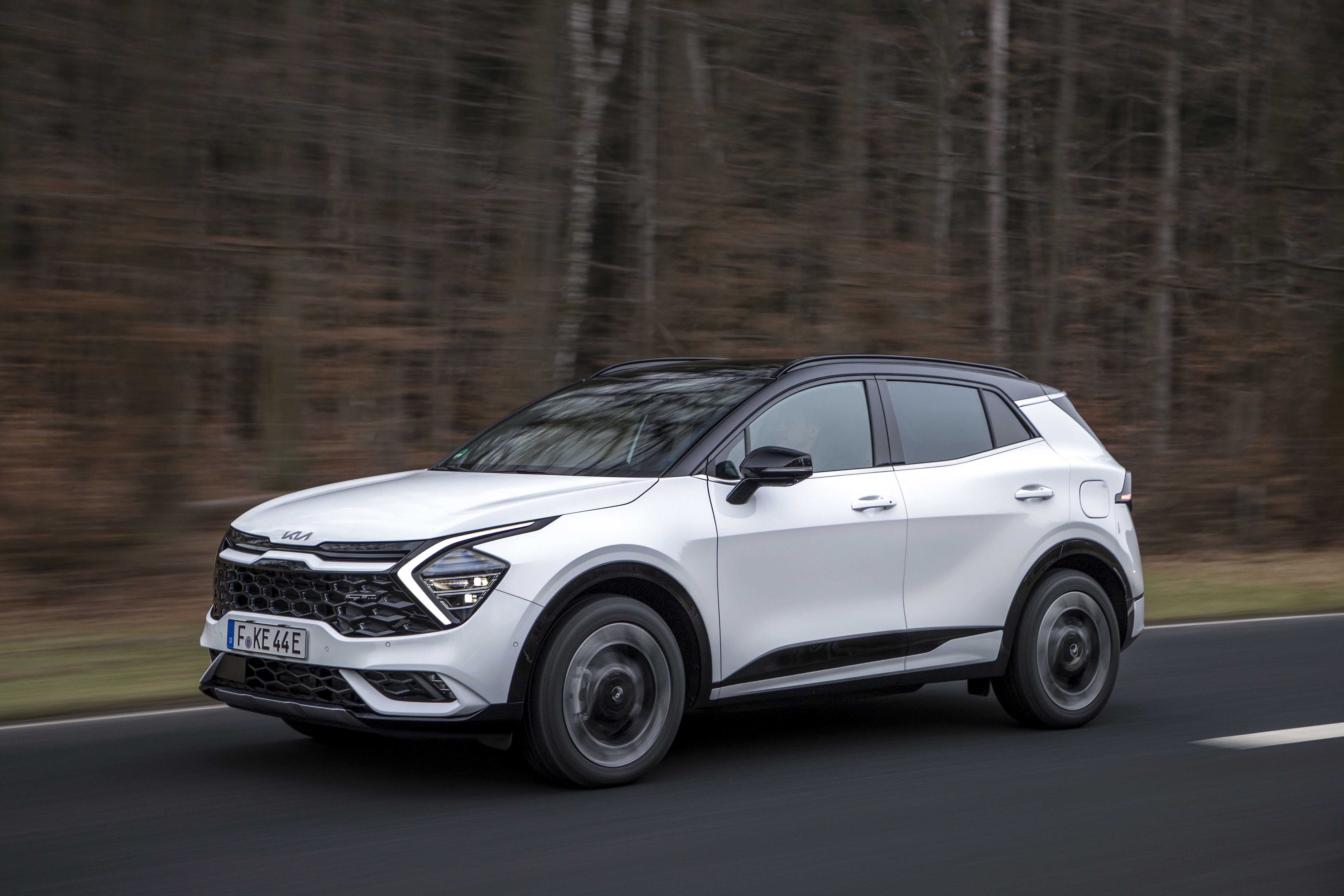 White Kia Sportage GT-Line PHEV driving on a road HD Wallpaper