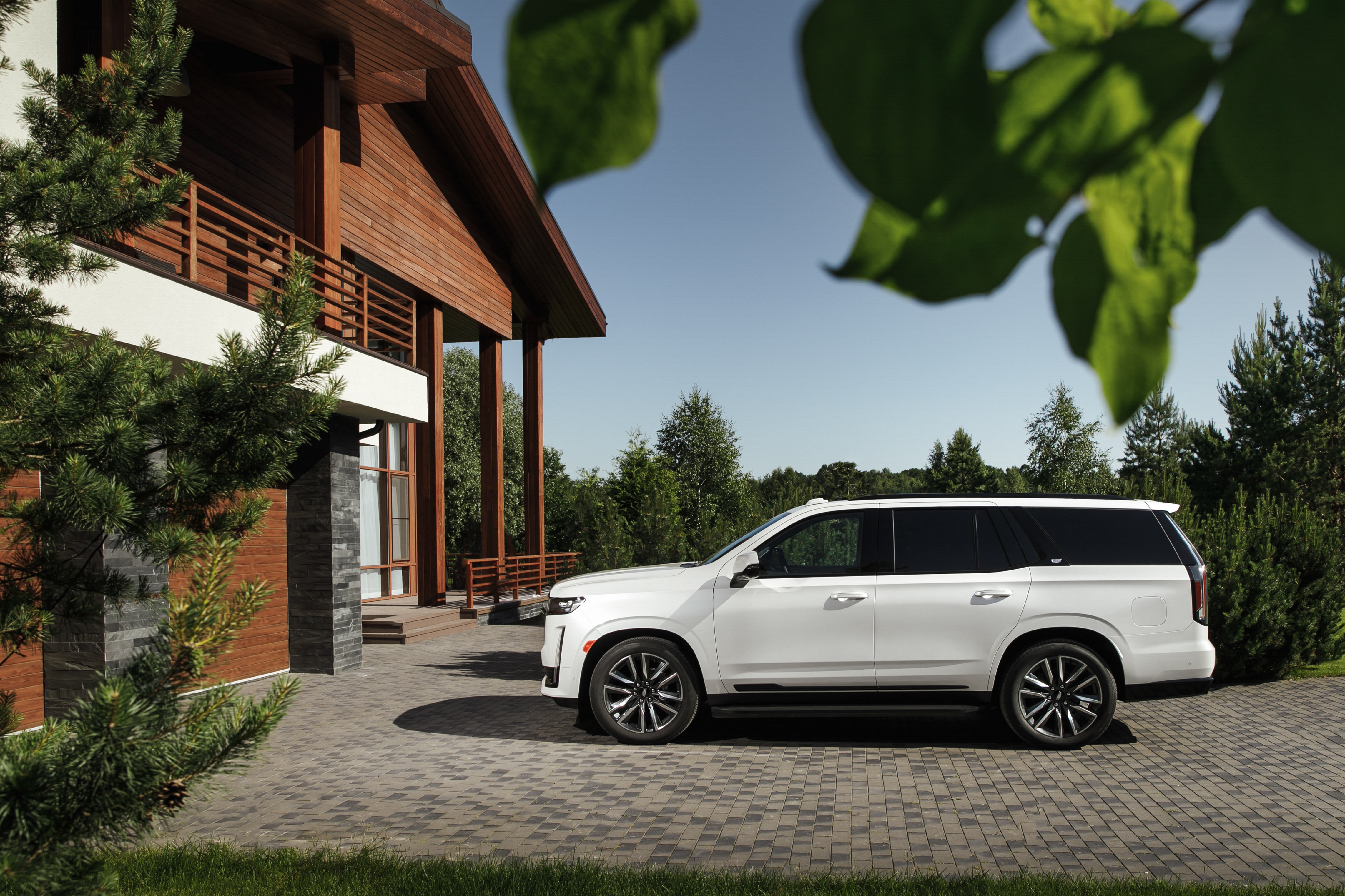 White Cadillac Escalade SUV parked near a wooden house HD Wallpaper