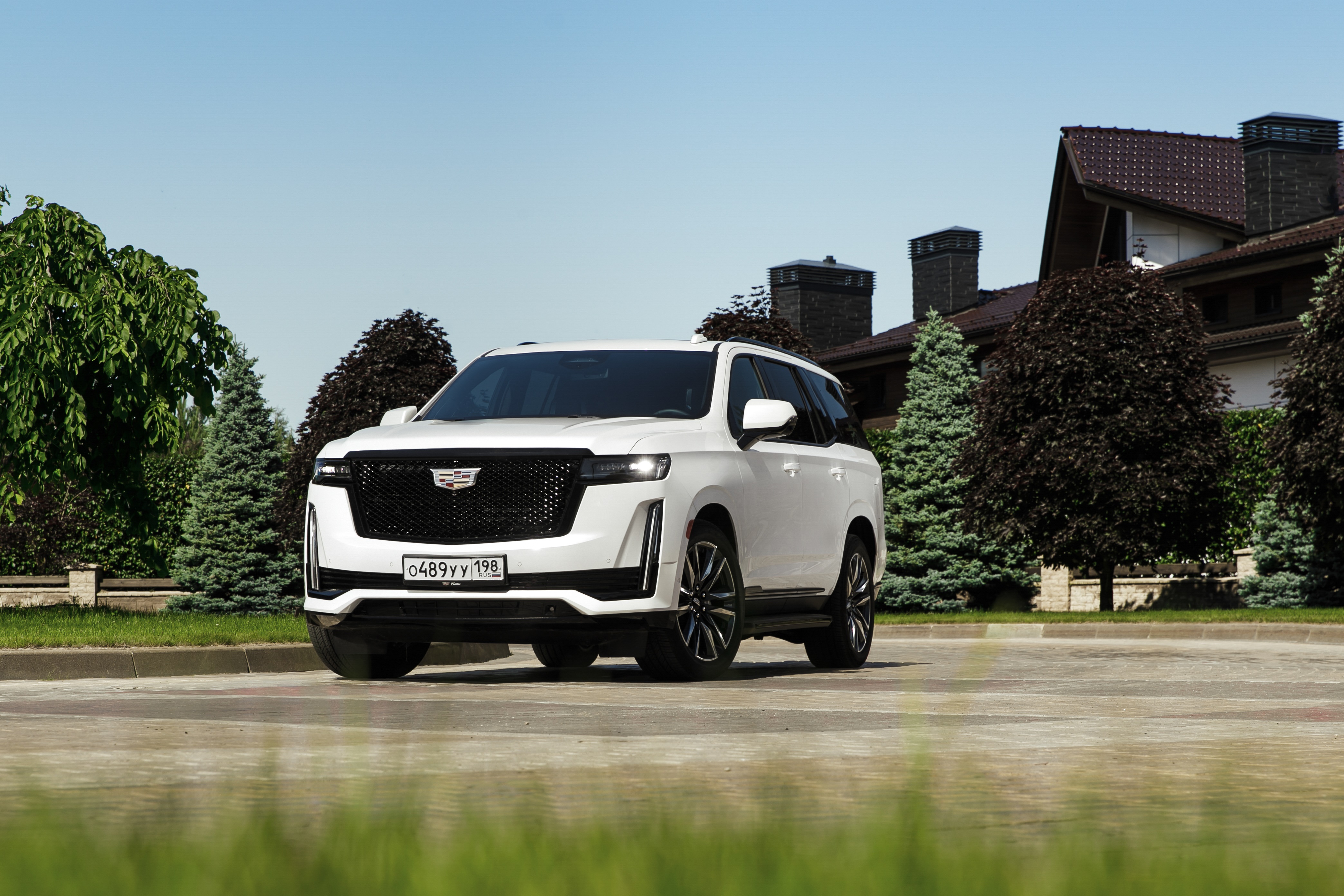 White Cadillac Escalade SUV parked in front of houses HD Wallpaper