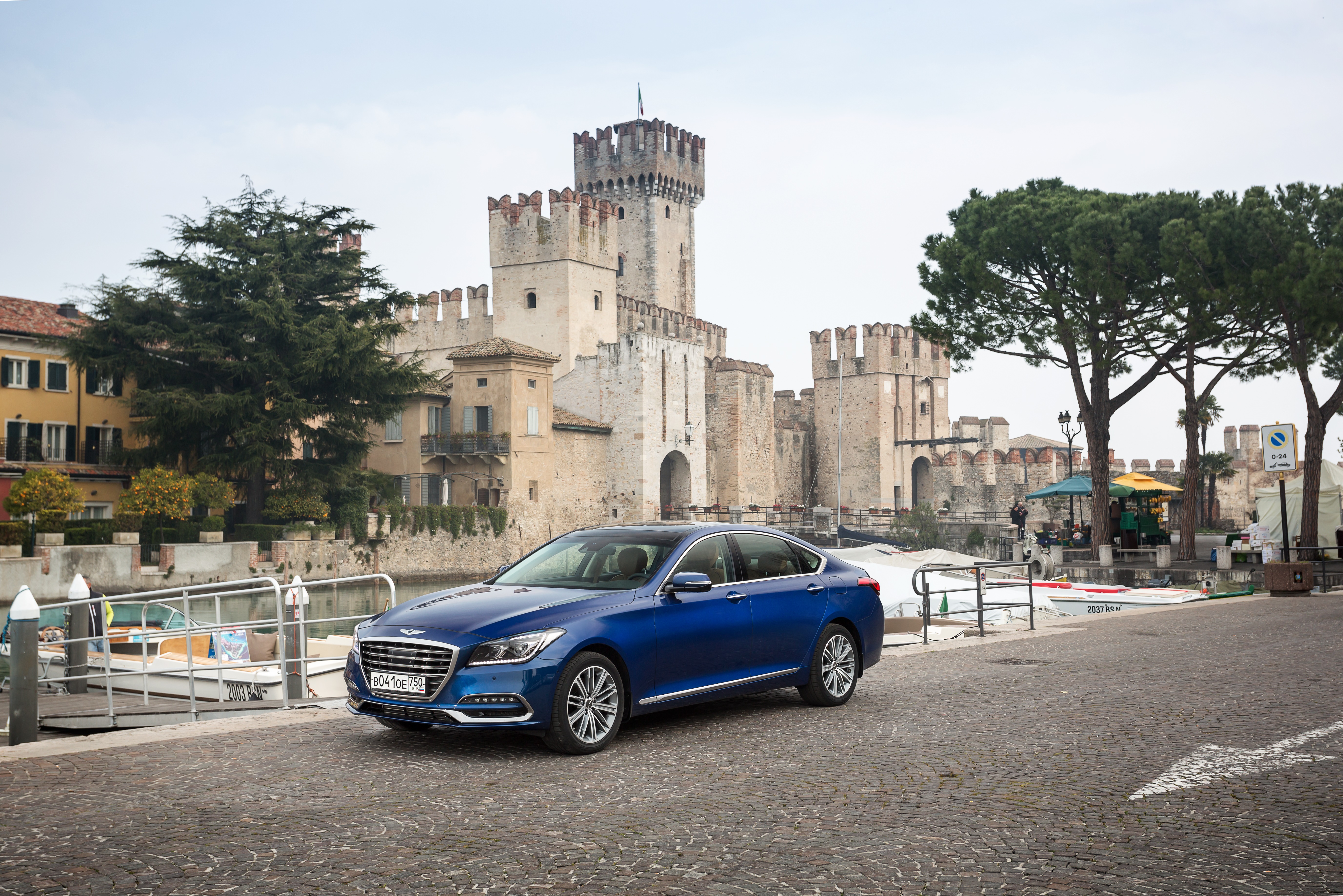 Blue Genesis G80 Sedan parked near a castle HD Wallpaper