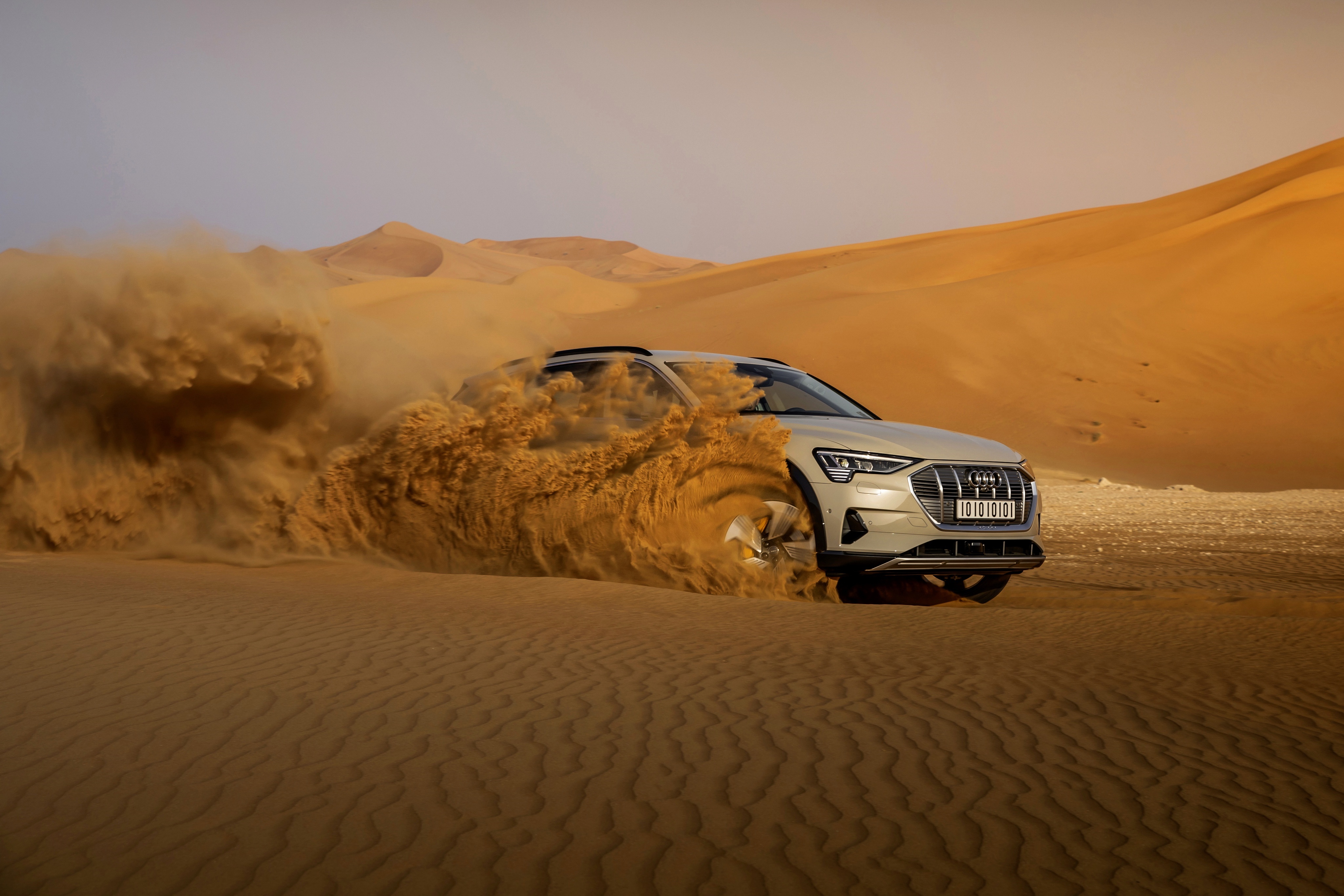 Audi E-Tron SUV driving through desert sand dunes HD Wallpaper