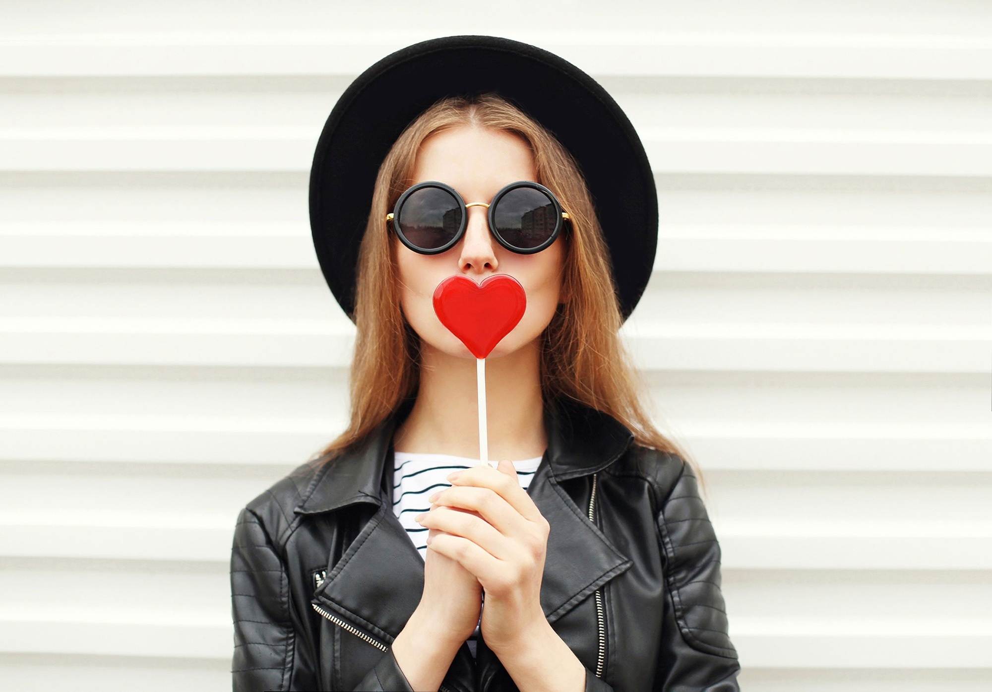 Woman in hat and sunglasses holding heart lollipop HD Wallpaper