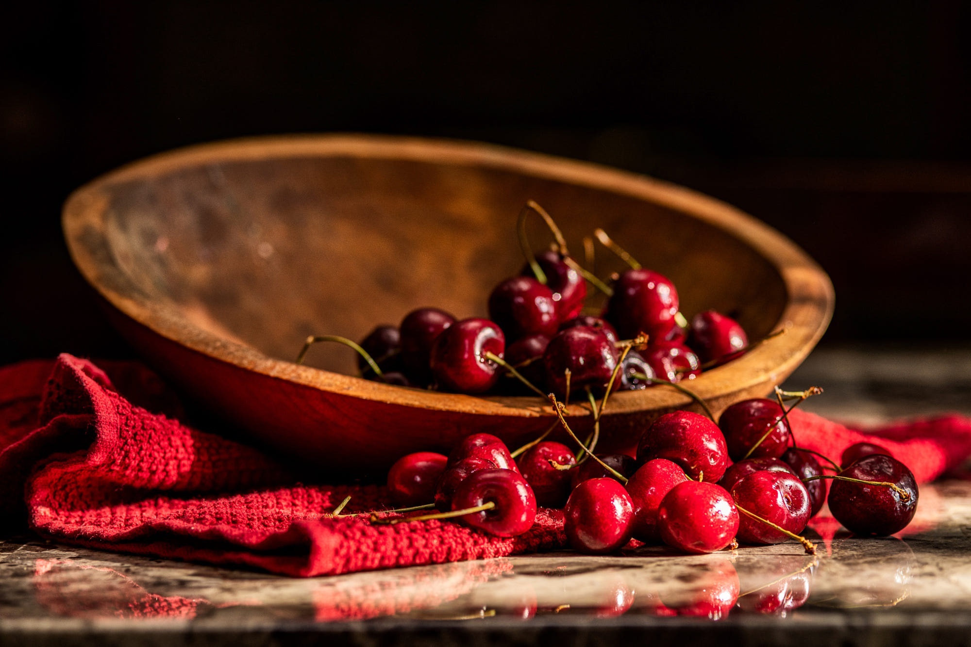 Cherries in a wooden bowl on a red cloth HD Wallpaper