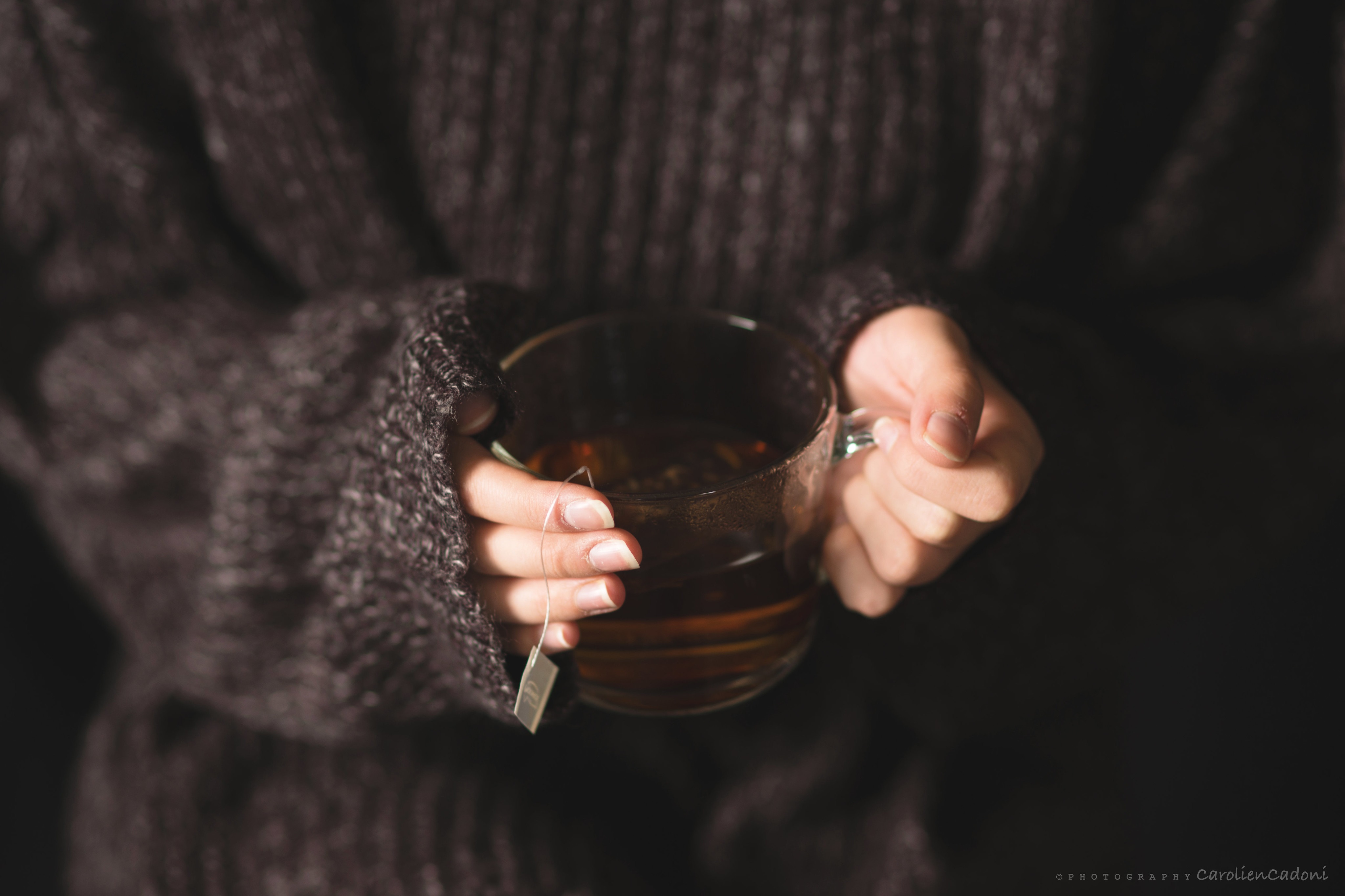 Person holding a cup of tea in a sweater HD Wallpaper