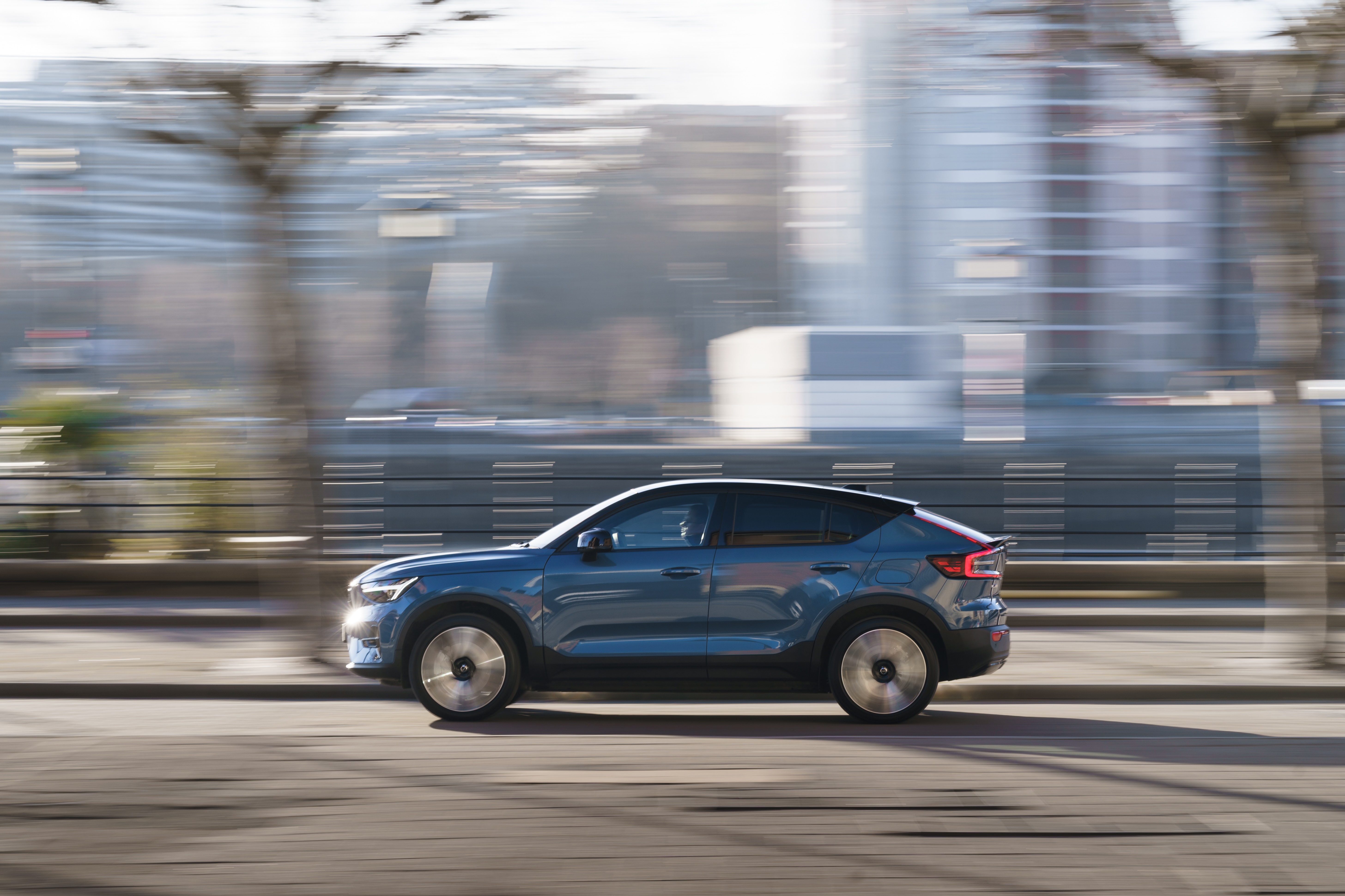 Blue Volvo C40 SUV driving on a street HD Wallpaper