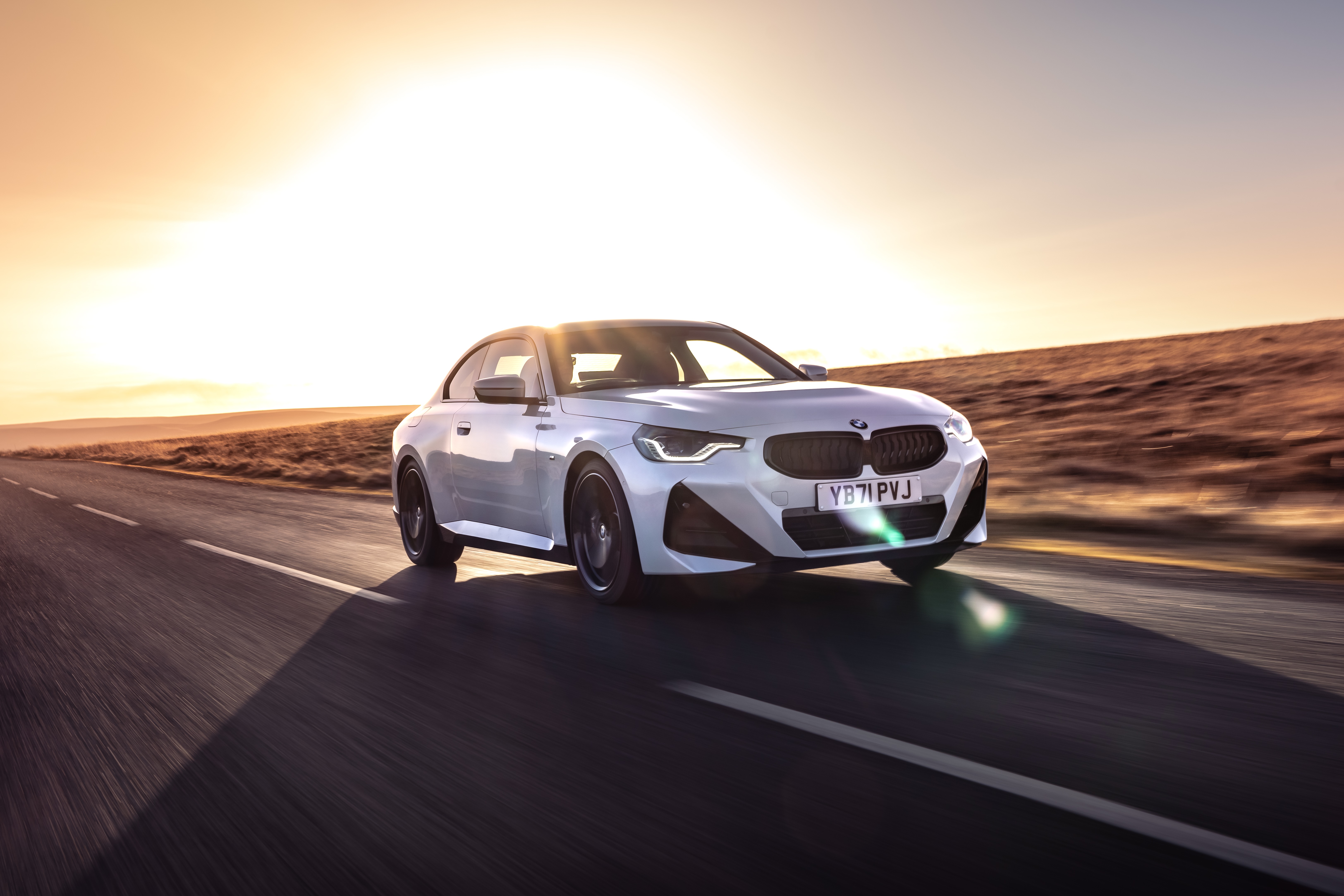 White BMW 220i Coupé M Sport driving on road HD Wallpaper