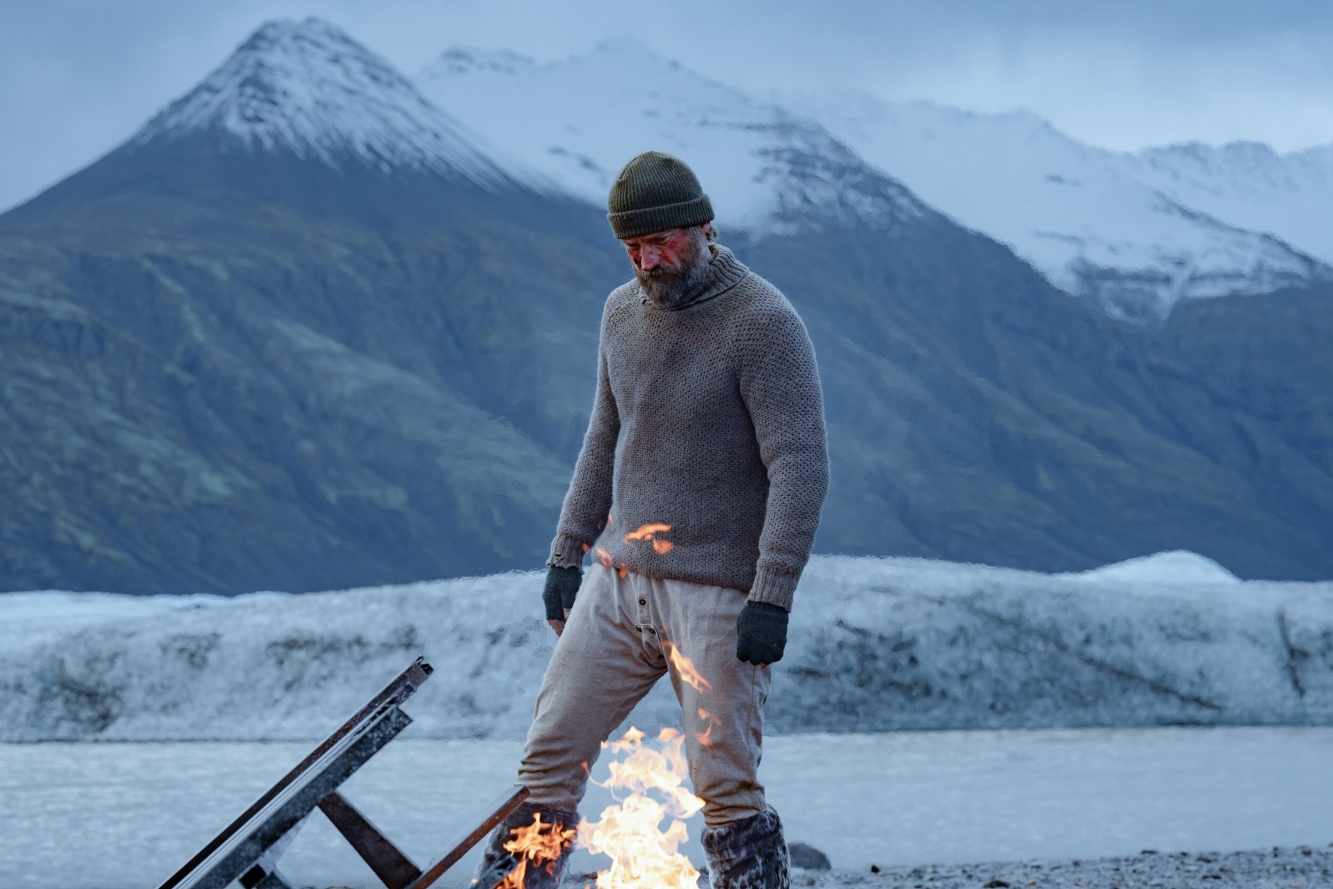 Man in sweater by fire in Iceland HD Wallpaper