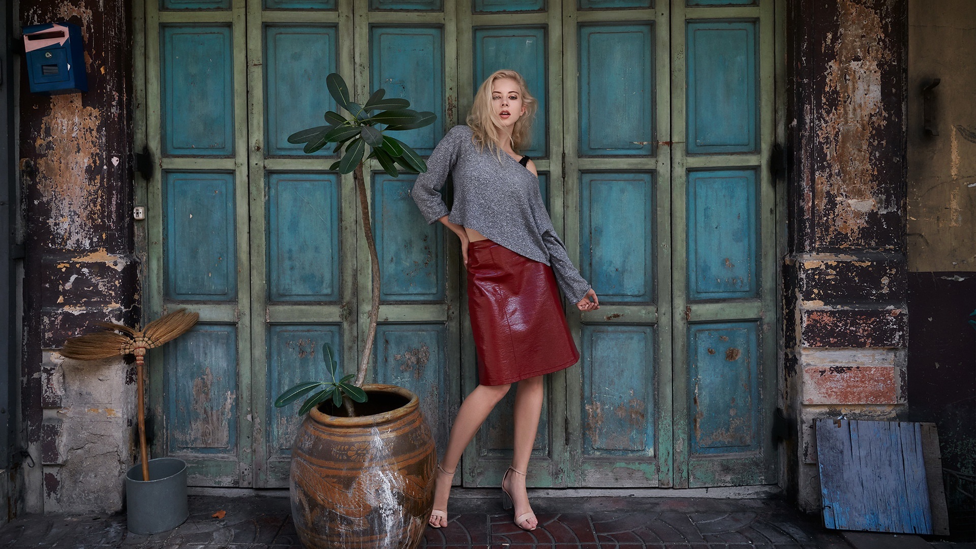 Woman in skirt and sweater in front of doors HD Wallpaper