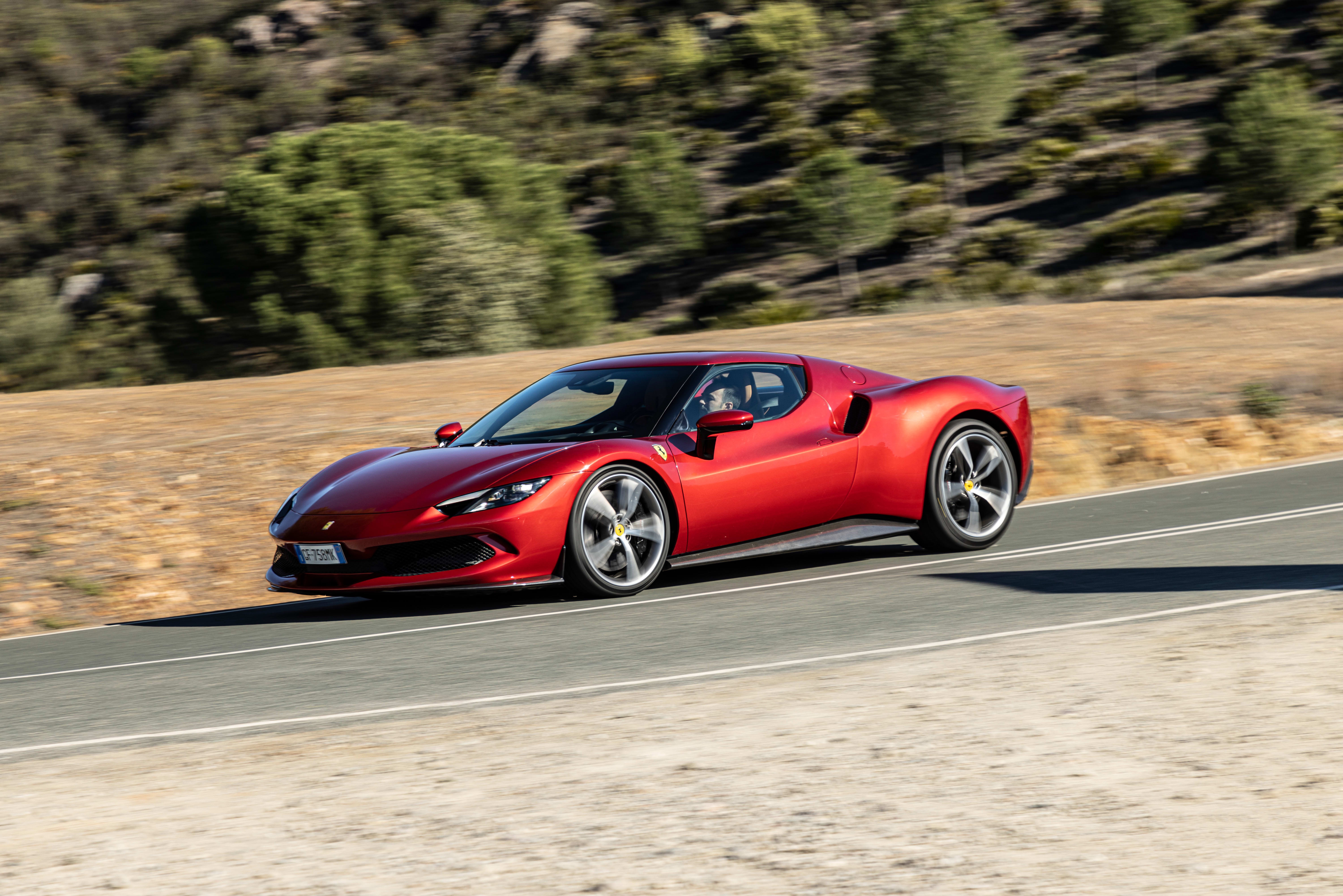 Red Ferrari 296 GTB driving on a road HD Wallpaper