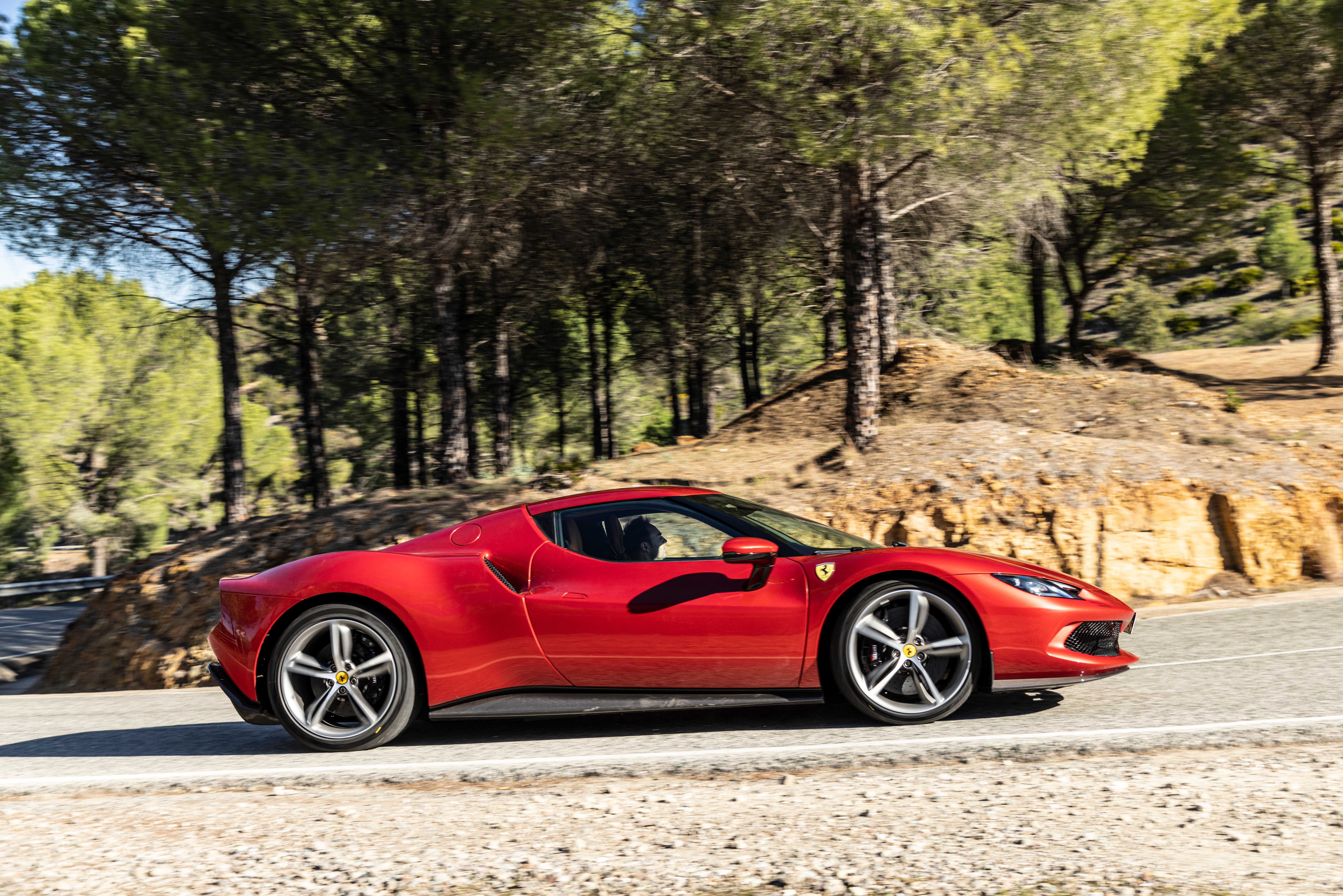 Red Ferrari 296 GTB driving on a road HD Wallpaper
