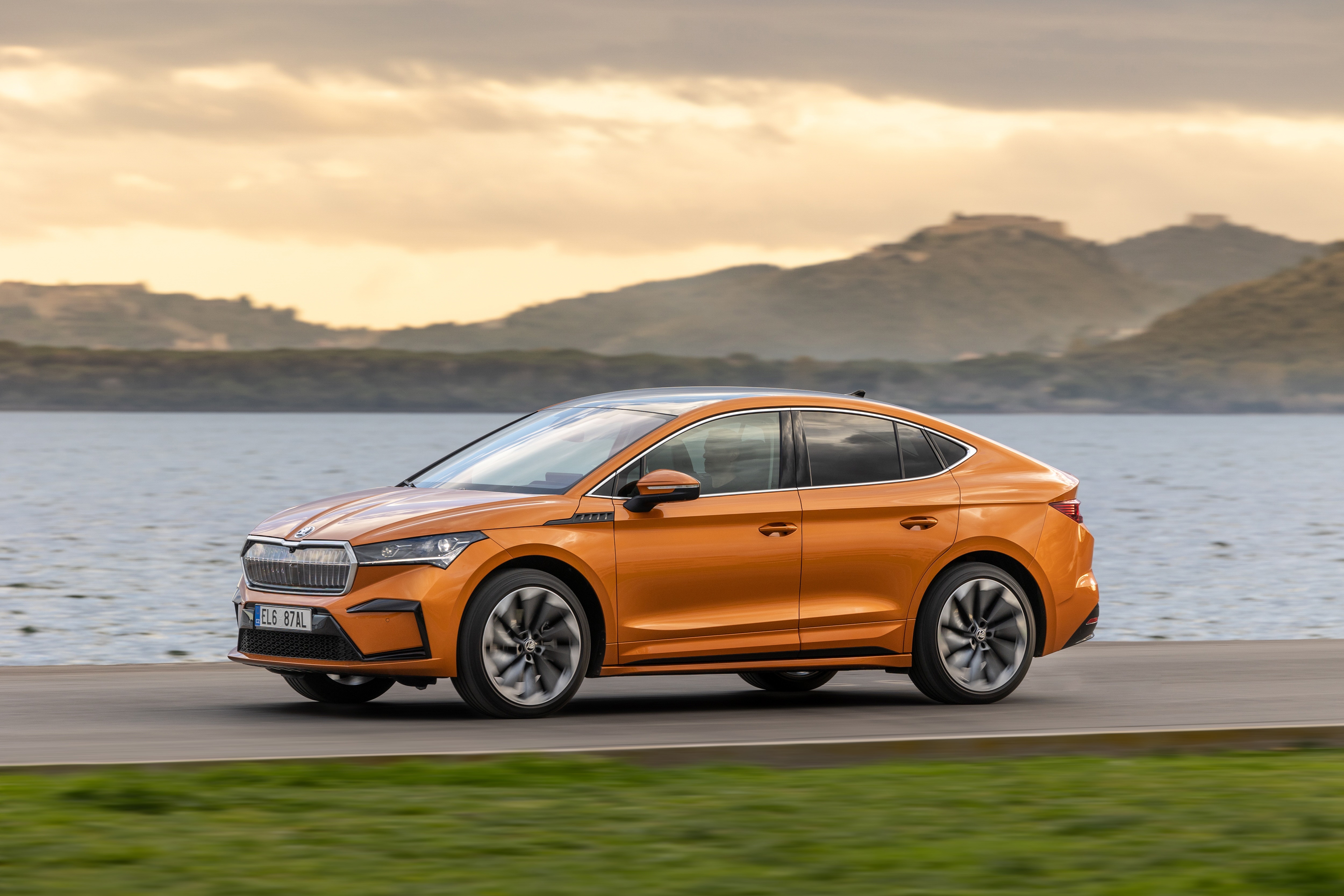Orange Škoda Enyaq IV 80 4K driving on road HD Wallpaper