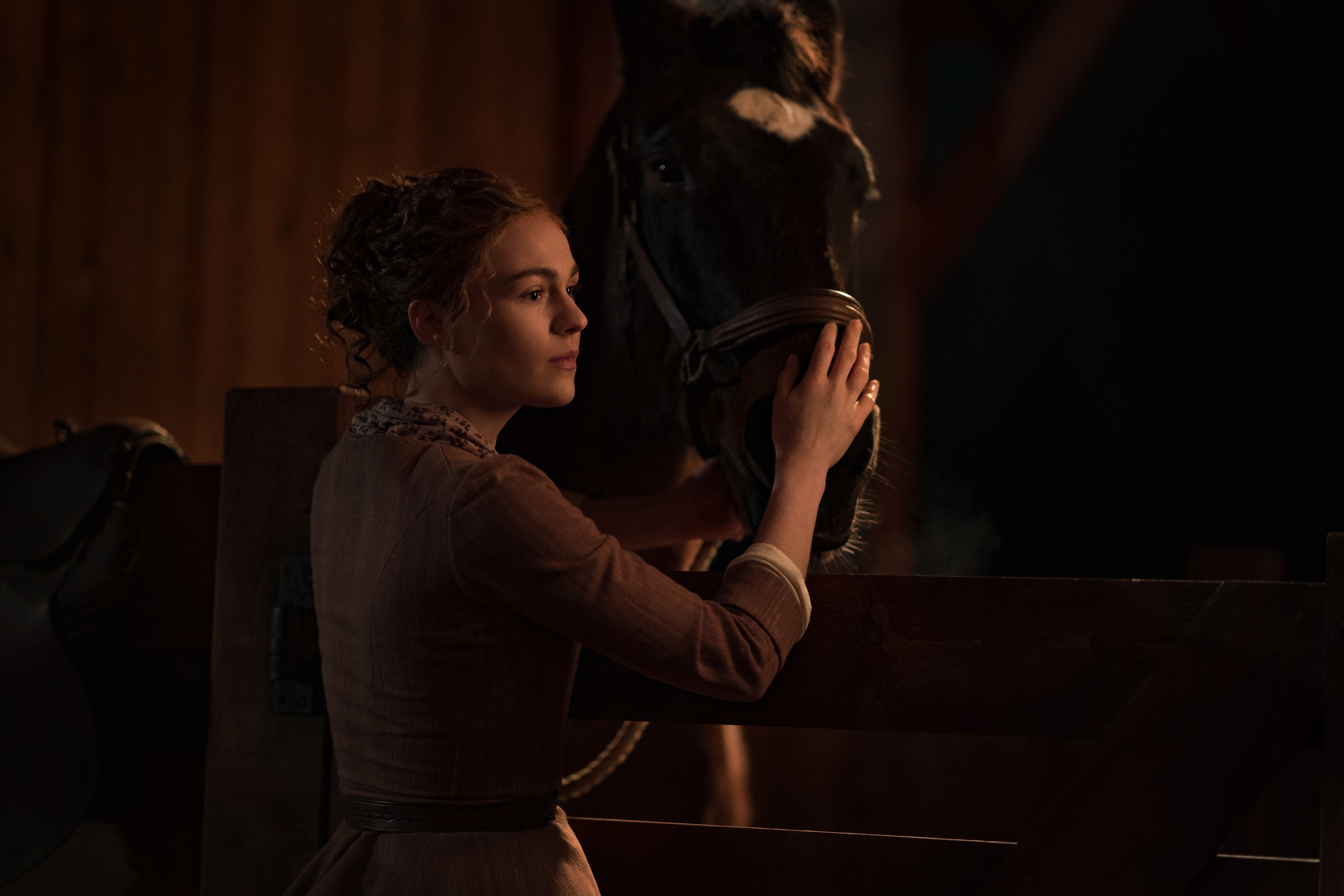 Woman petting a horse in a stable HD Wallpaper