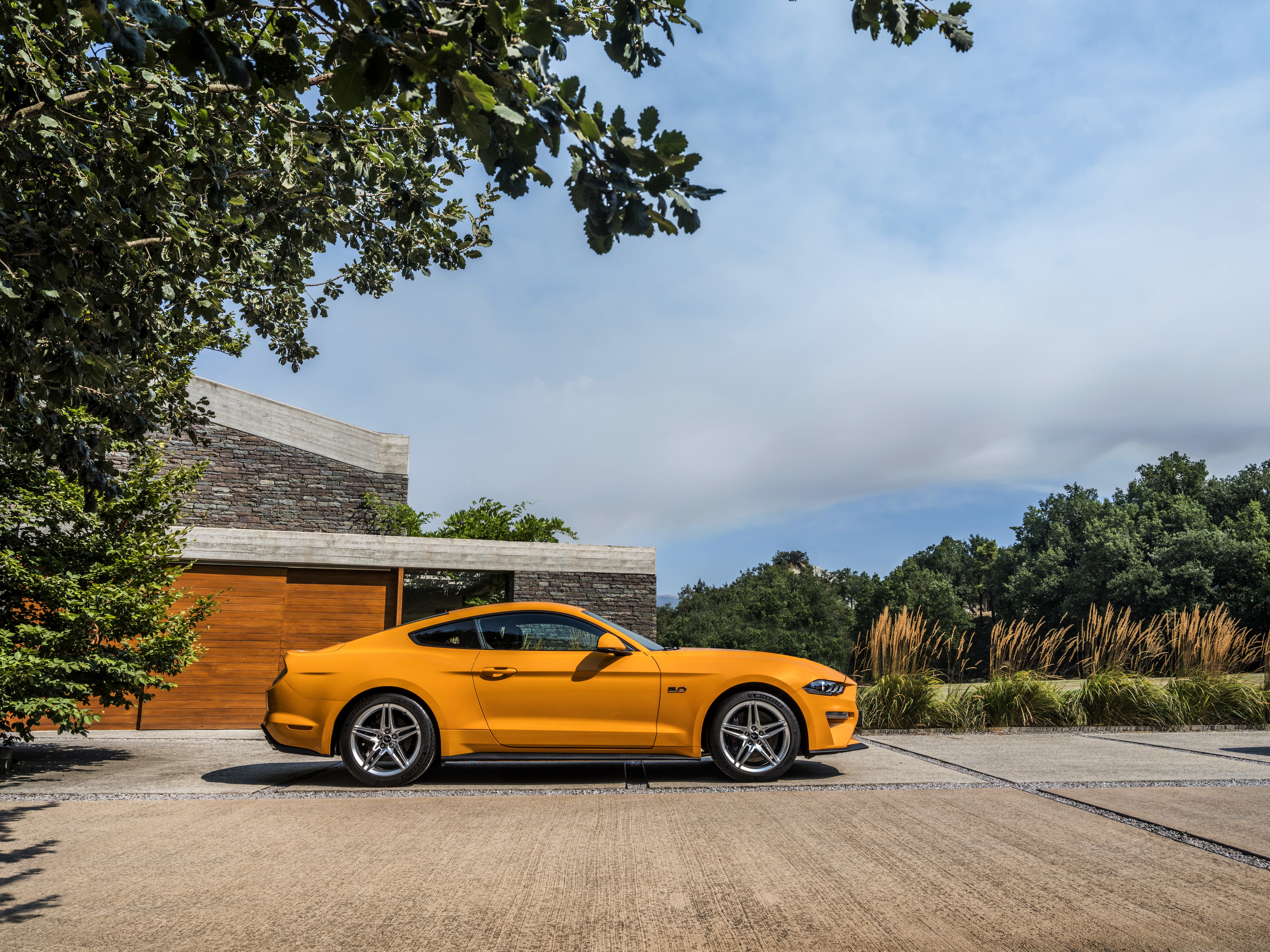 Yellow Ford Mustang GT parked in front of a modern house HD Wallpaper