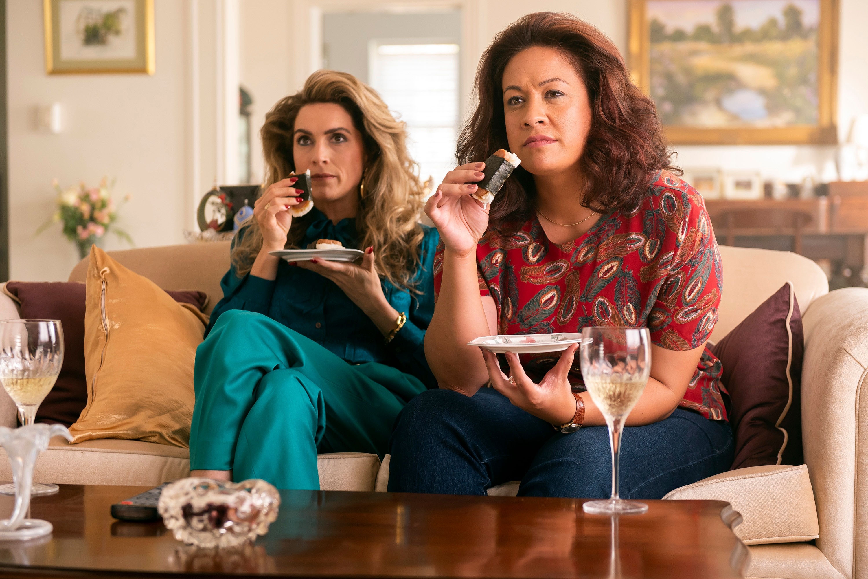 Two women eating snacks on a couch HD Wallpaper