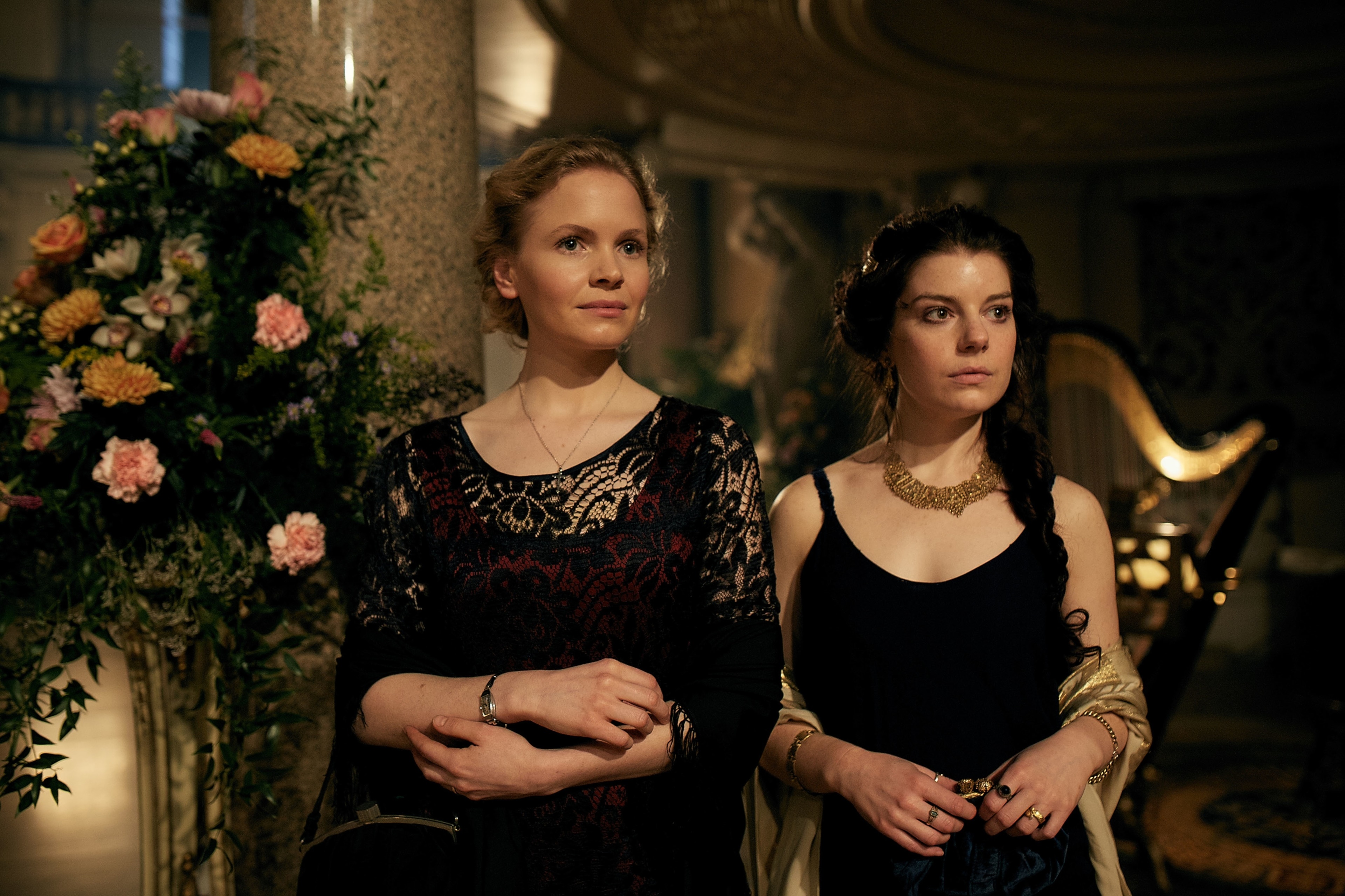 Two women in formal attire with a harp in the background HD Wallpaper