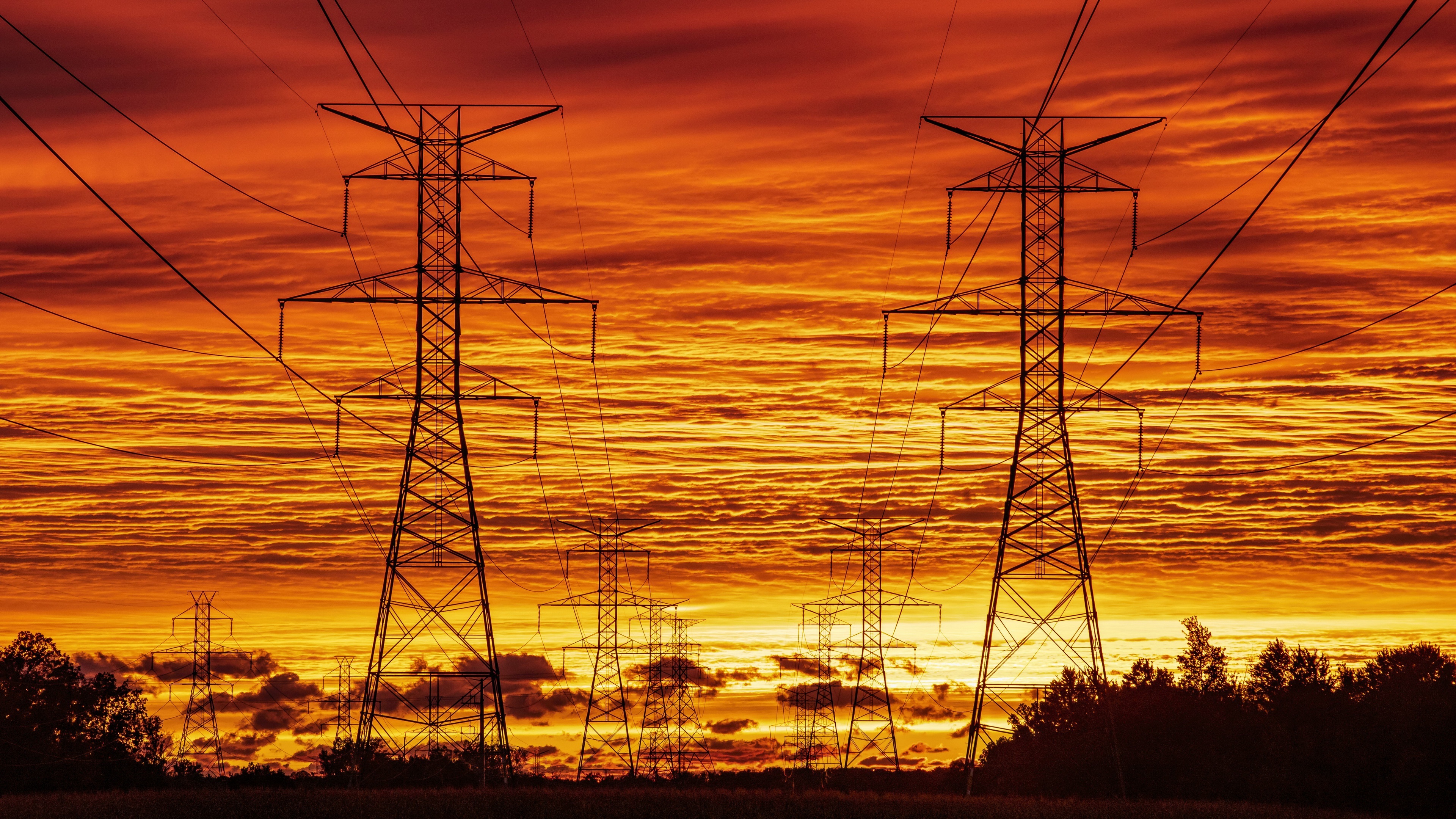 Power lines against a dramatic sunset sky HD Wallpaper