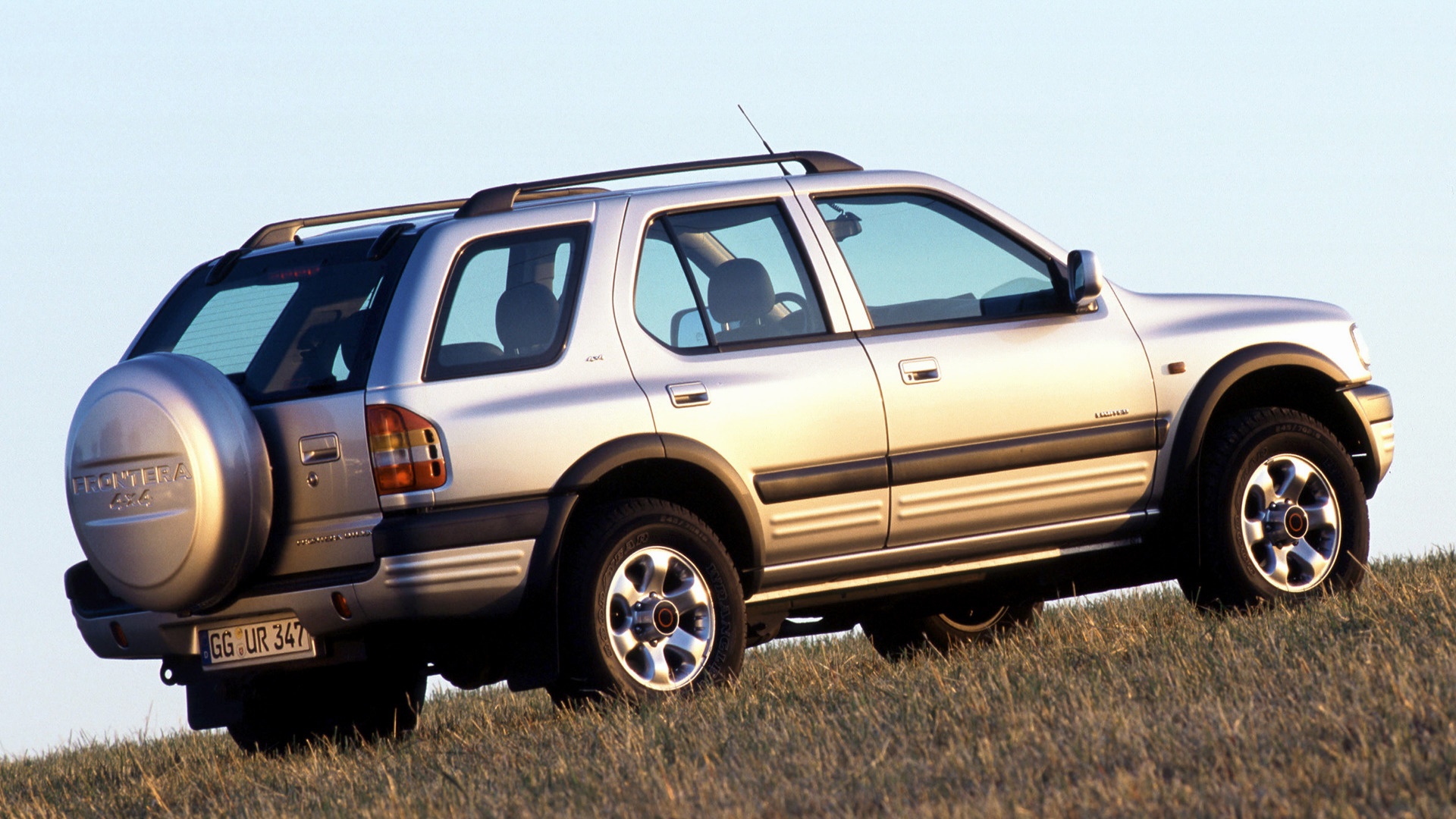 Silver Opel Frontera 4x4 parked on a grassy hill HD Wallpaper