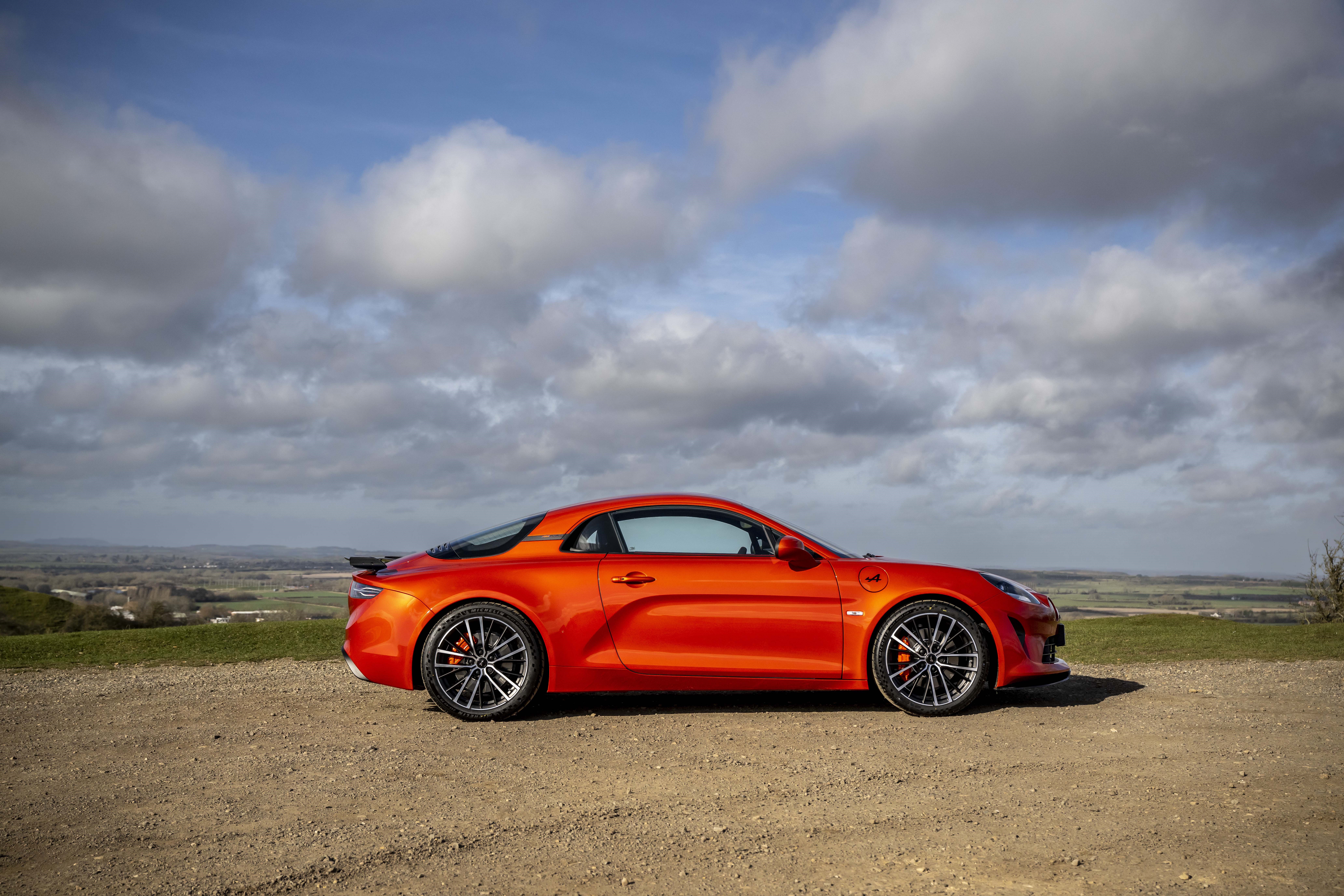 Orange Alpine A110S sports car on a dirt road HD Wallpaper