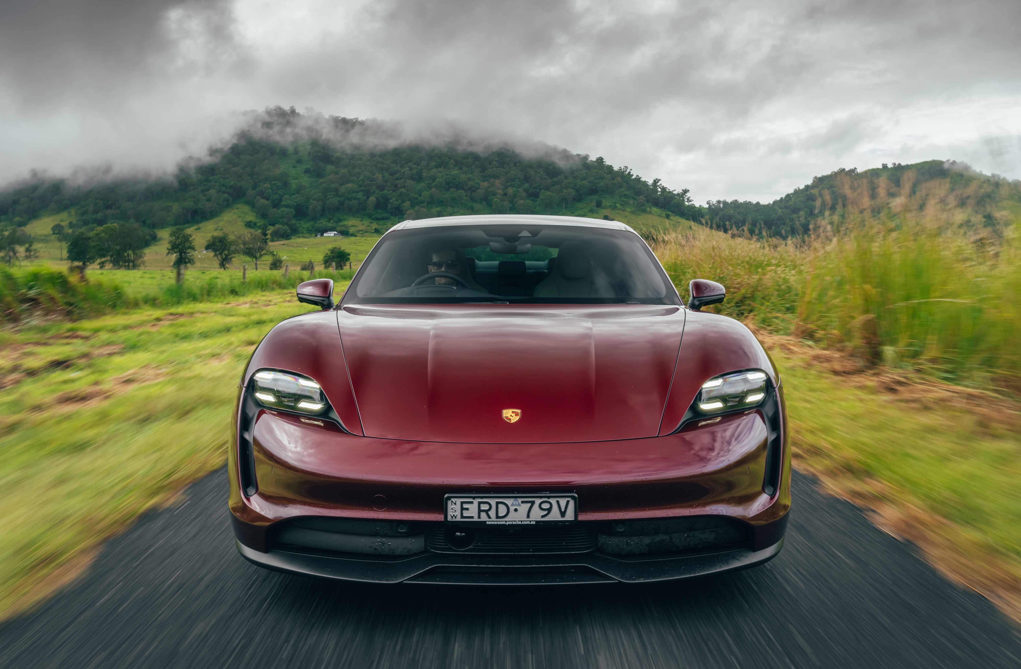 Red Porsche Taycan driving on a road HD Wallpaper