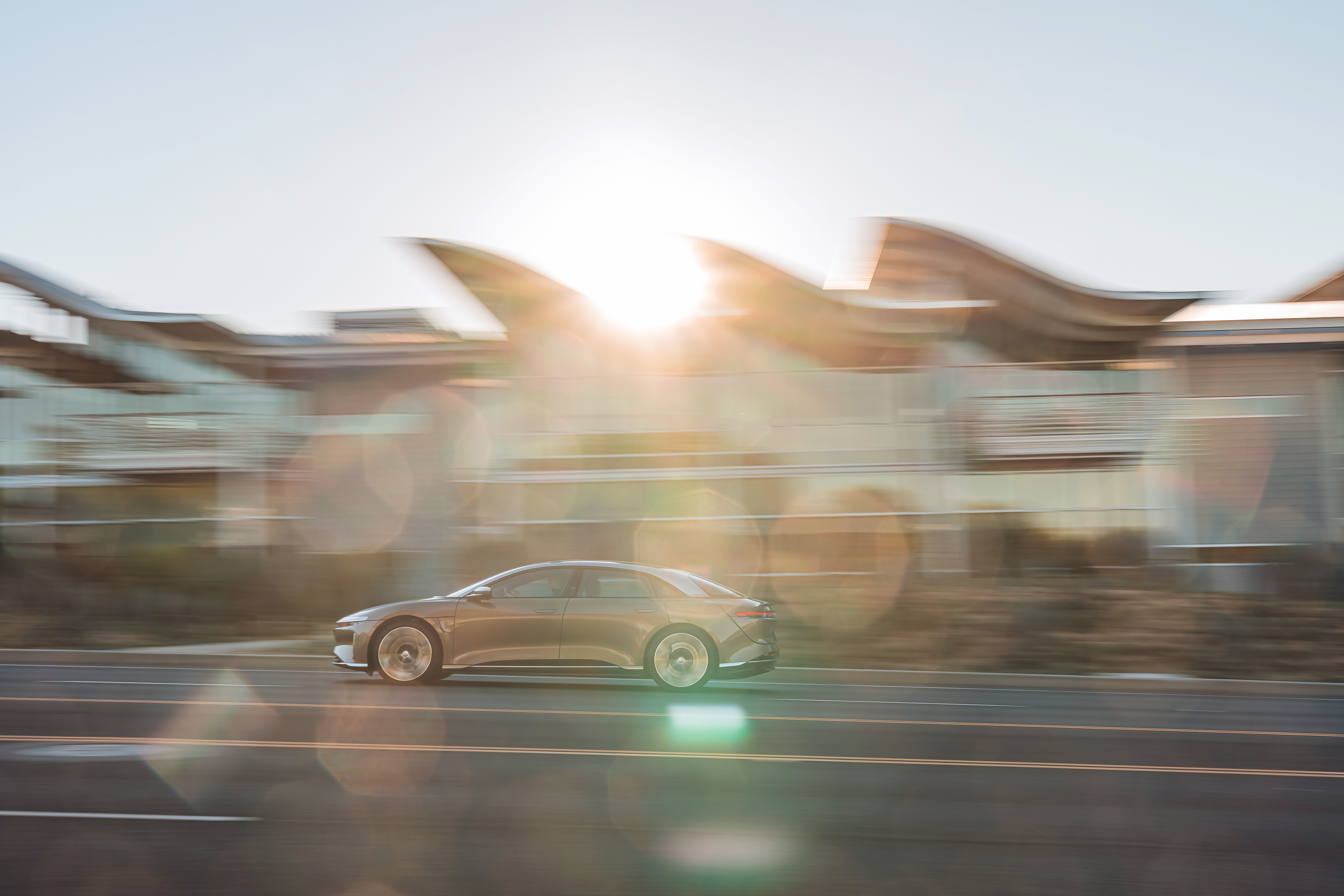 Lucid Air Dream Edition driving past building HD Wallpaper