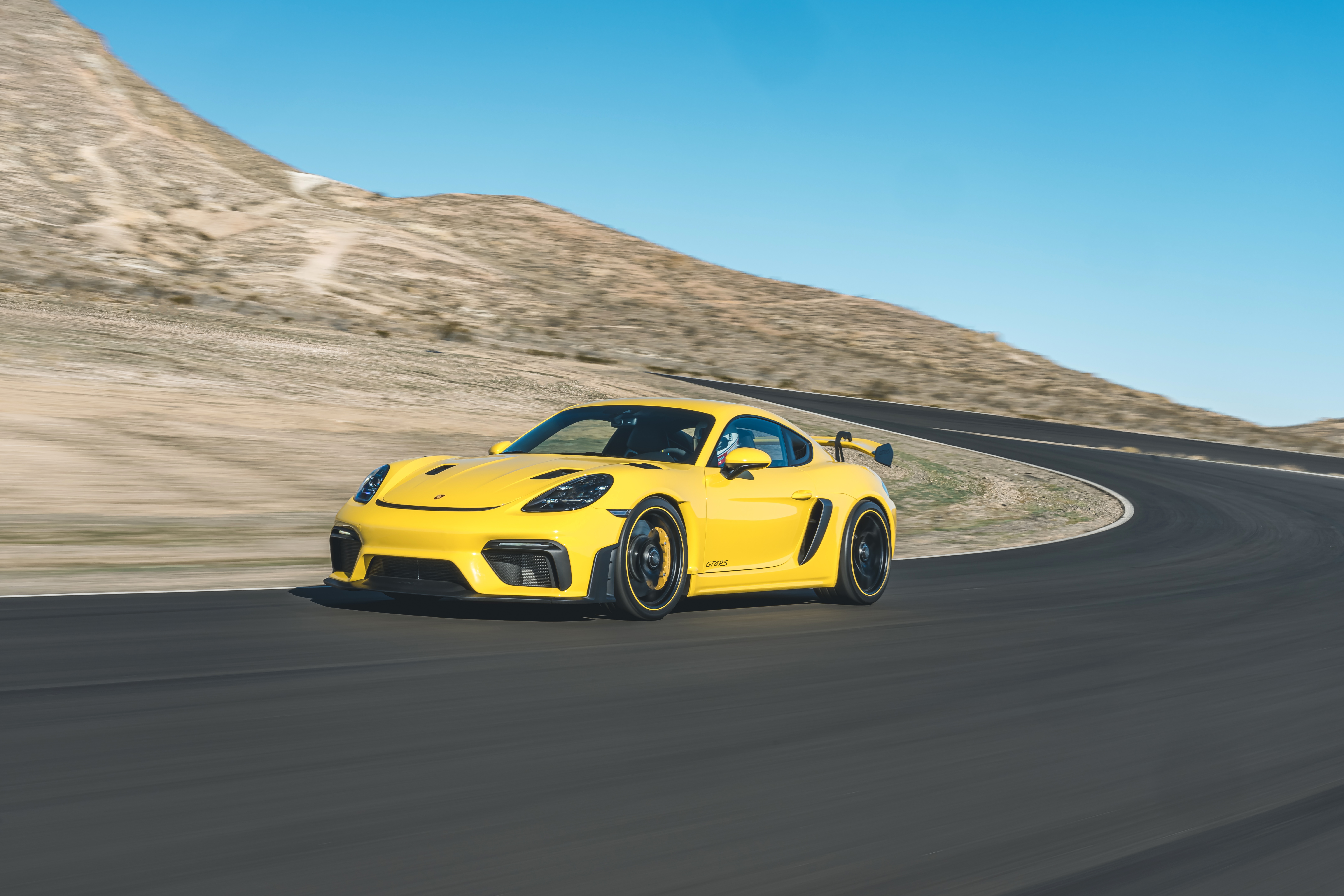 Yellow Porsche 718 Cayman GT4 on a Racetrack HD Wallpaper