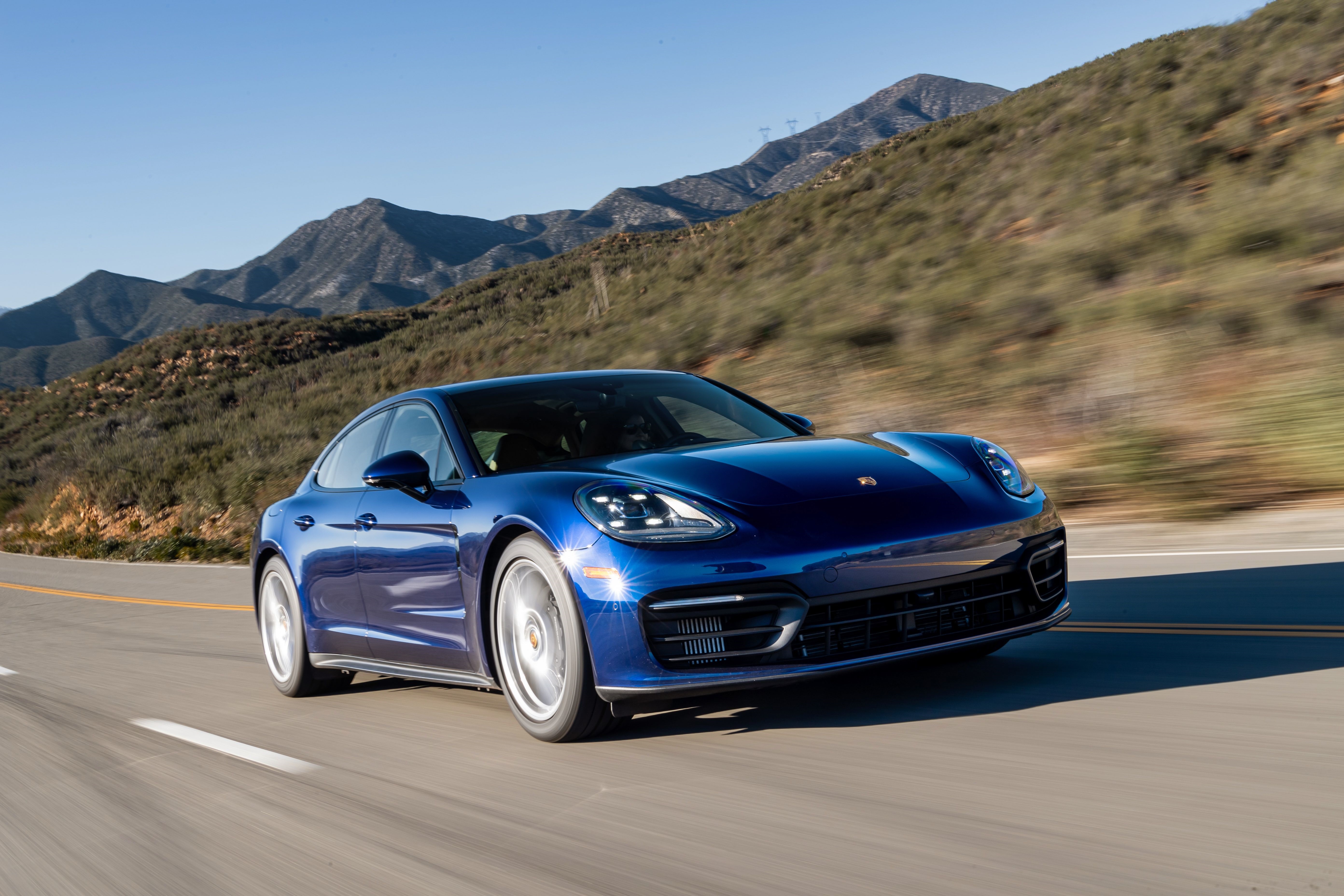 Blue Porsche Panamera driving on a mountain road HD Wallpaper