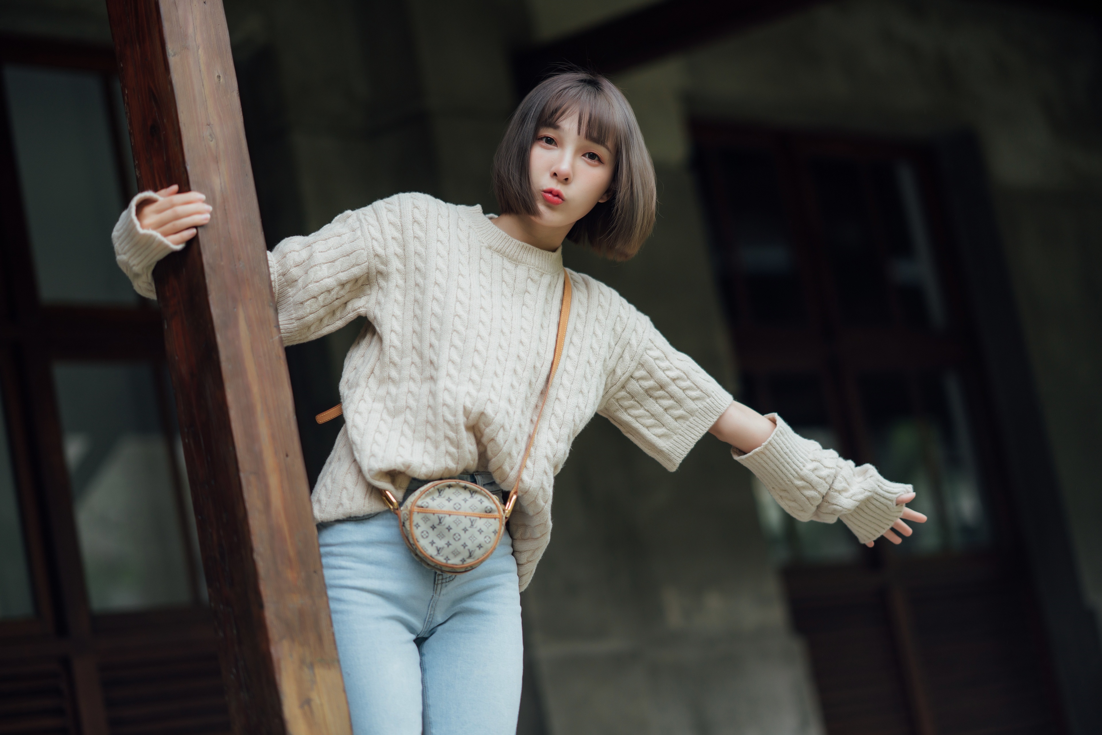 Asian woman in sweater and jeans with round bag HD Wallpaper