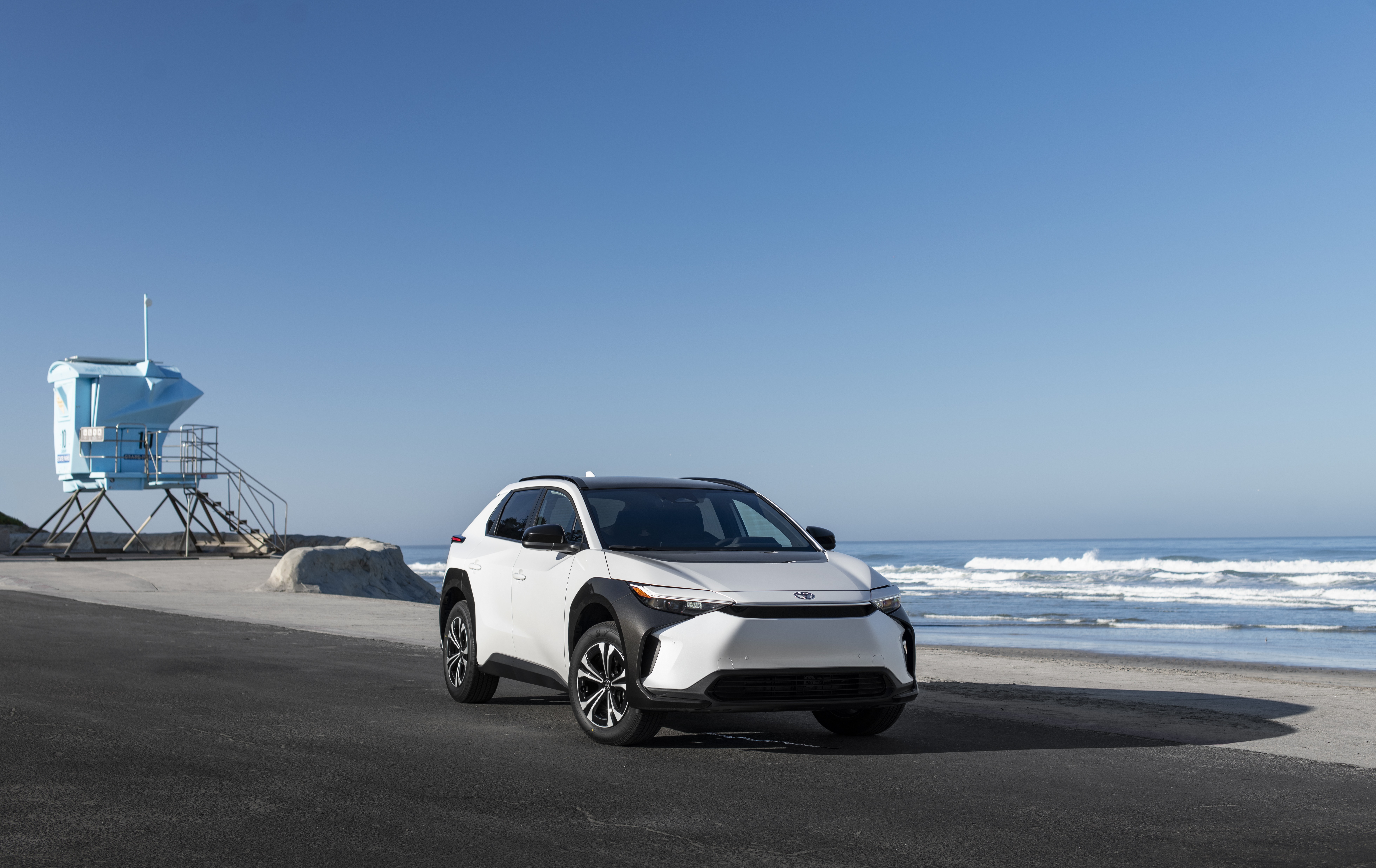 White Toyota BZ4X parked by the beach HD Wallpaper
