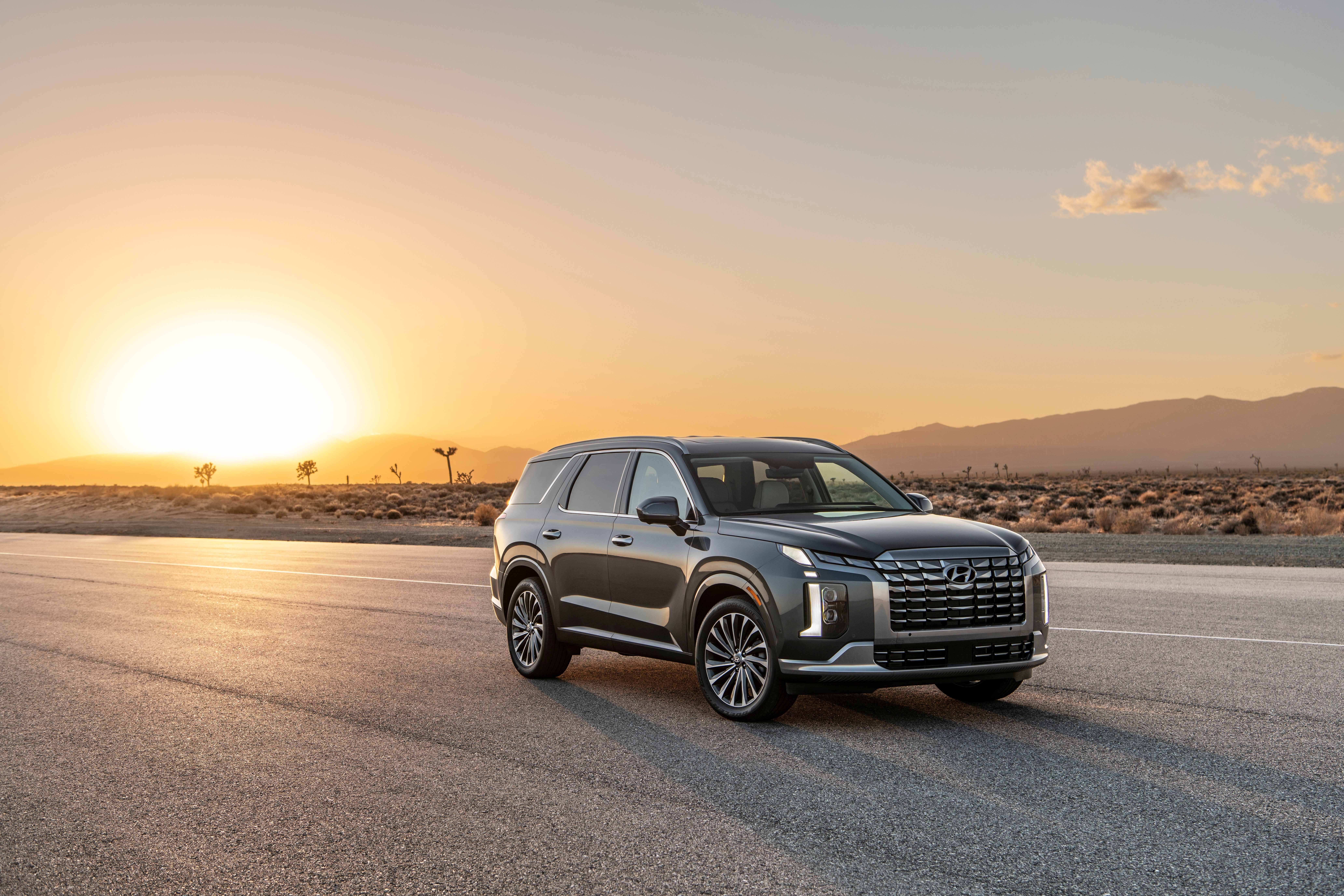 Hyundai Palisade SUV on a desert road at sunset HD Wallpaper
