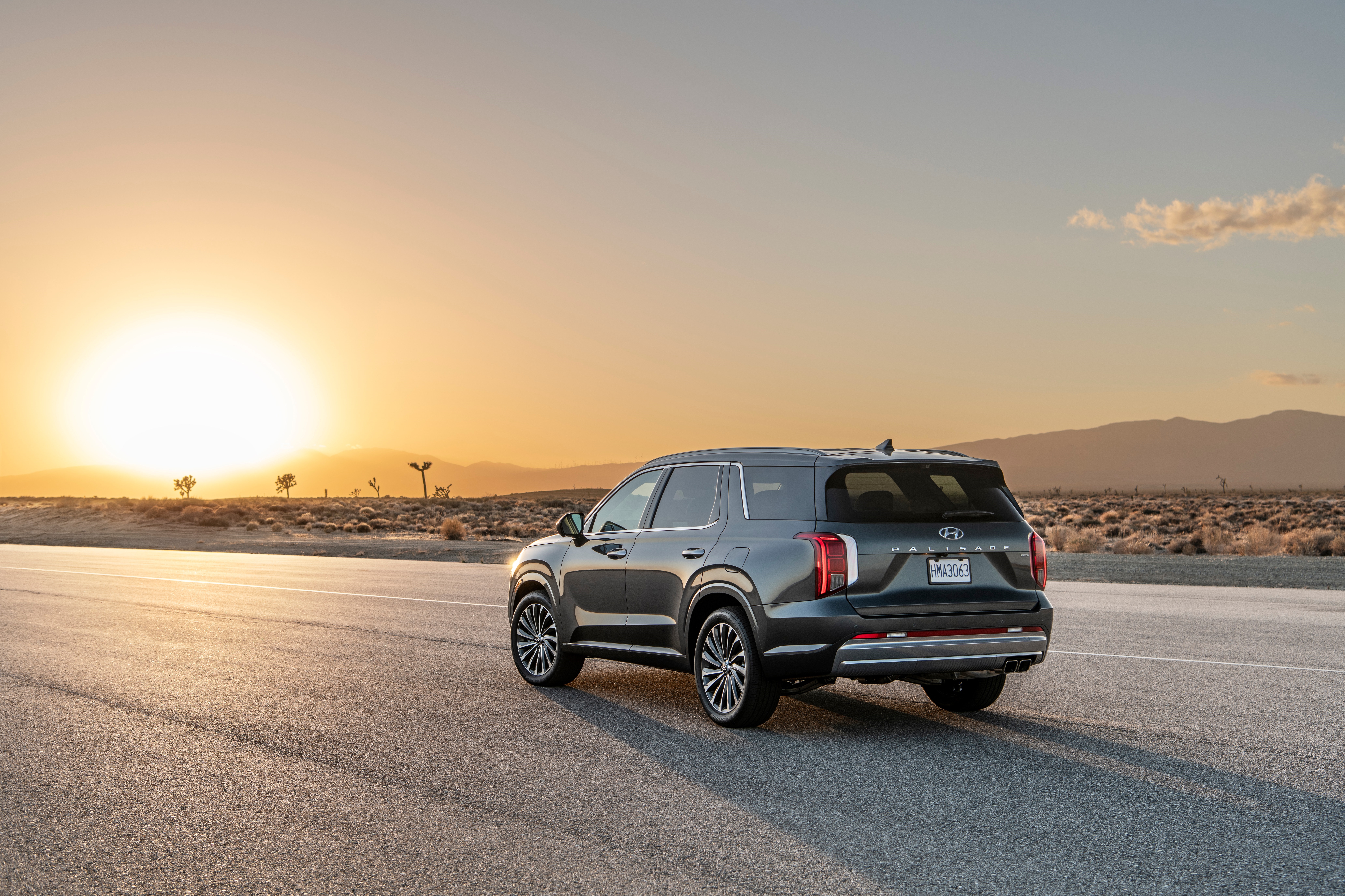 Hyundai Palisade SUV on a desert road at sunset HD Wallpaper