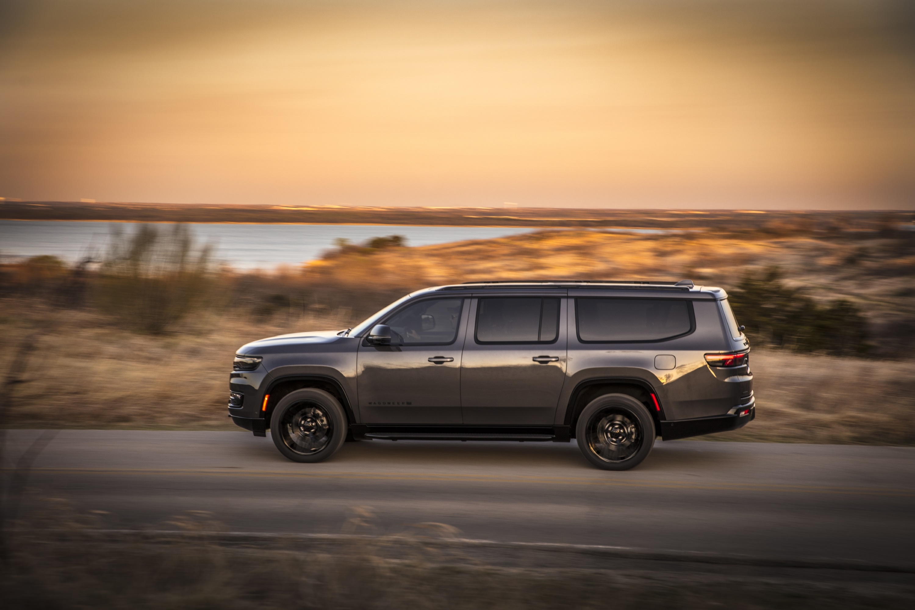Jeep Wagoneer driving on a road at sunset HD Wallpaper