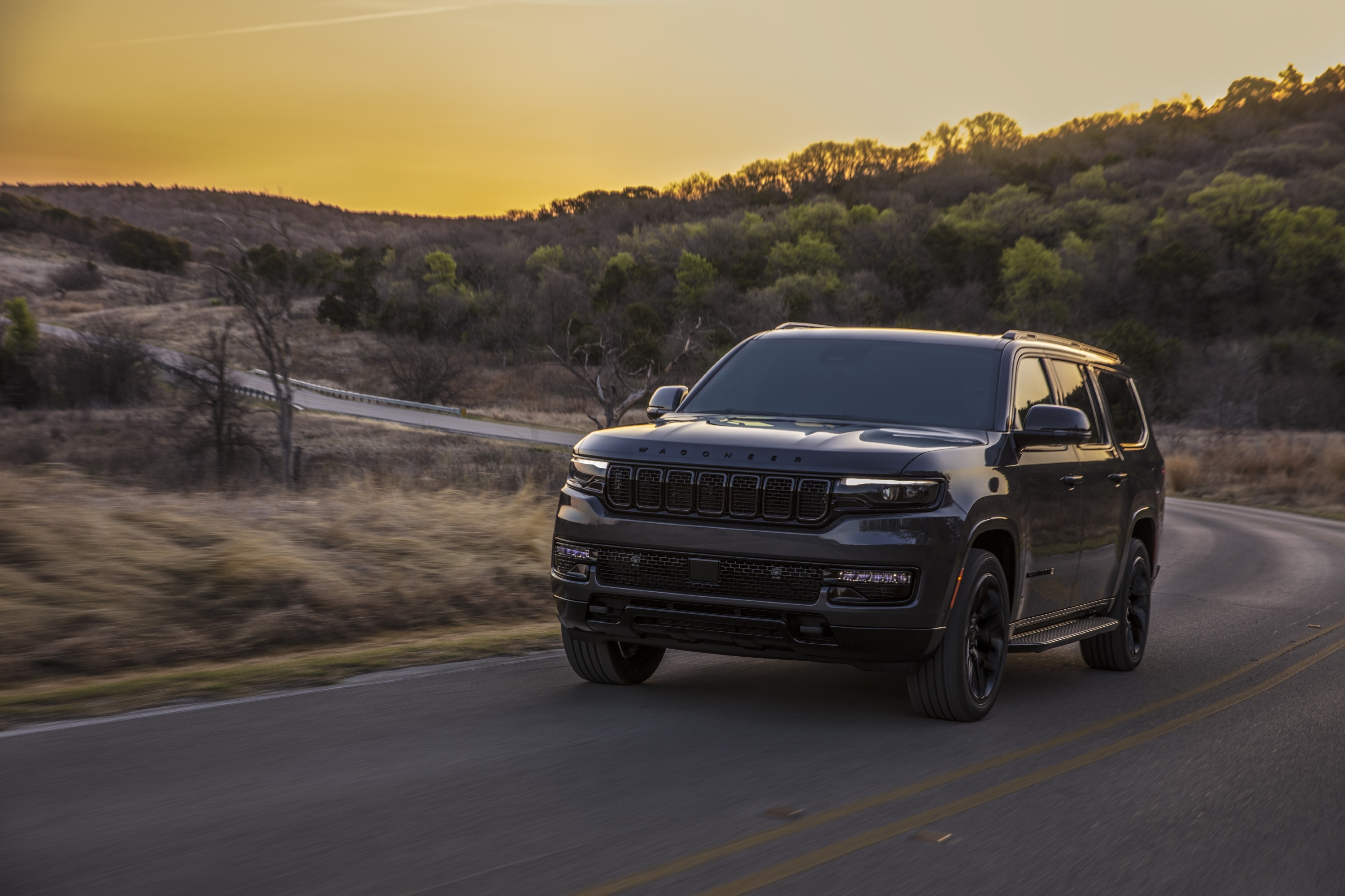 Dark Gray Jeep Wagoneer Driving on a Winding Road at Sunset HD Wallpaper