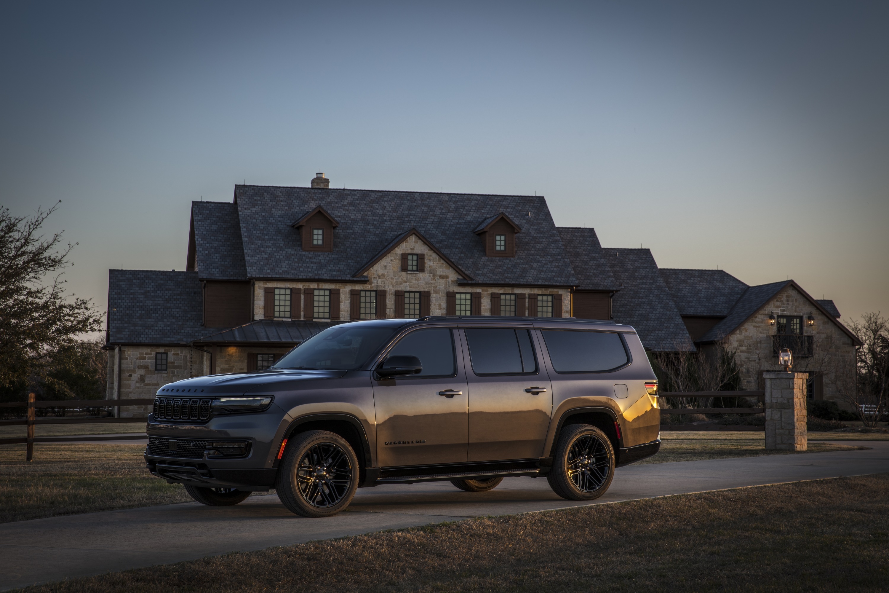 Jeep Wagoneer L parked in front of a large house HD Wallpaper