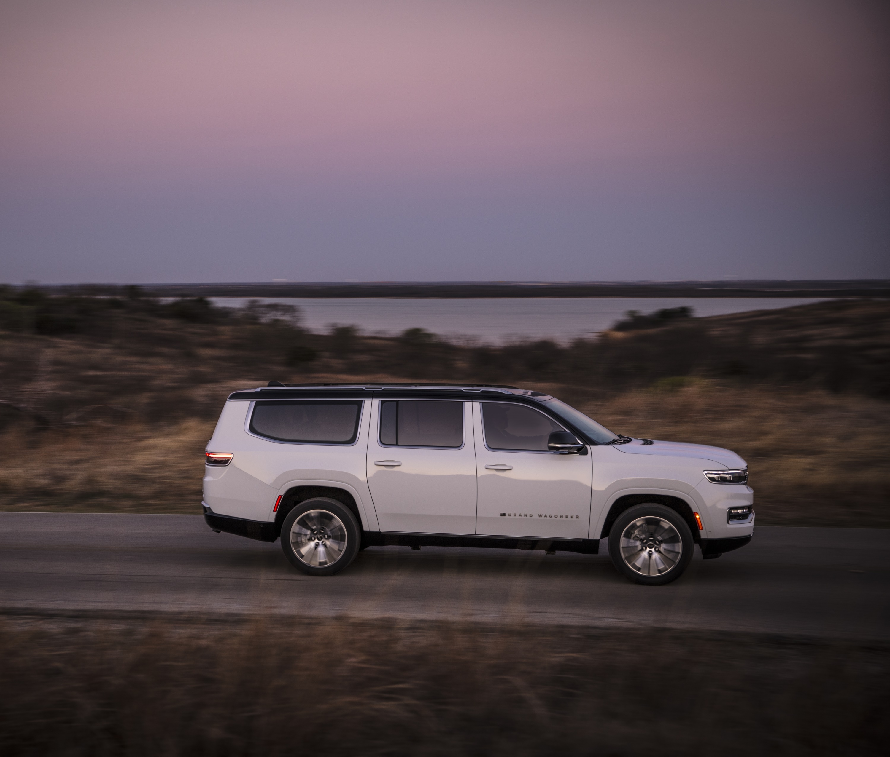 White Jeep Grand Wagoneer driving on a road at dusk HD Wallpaper