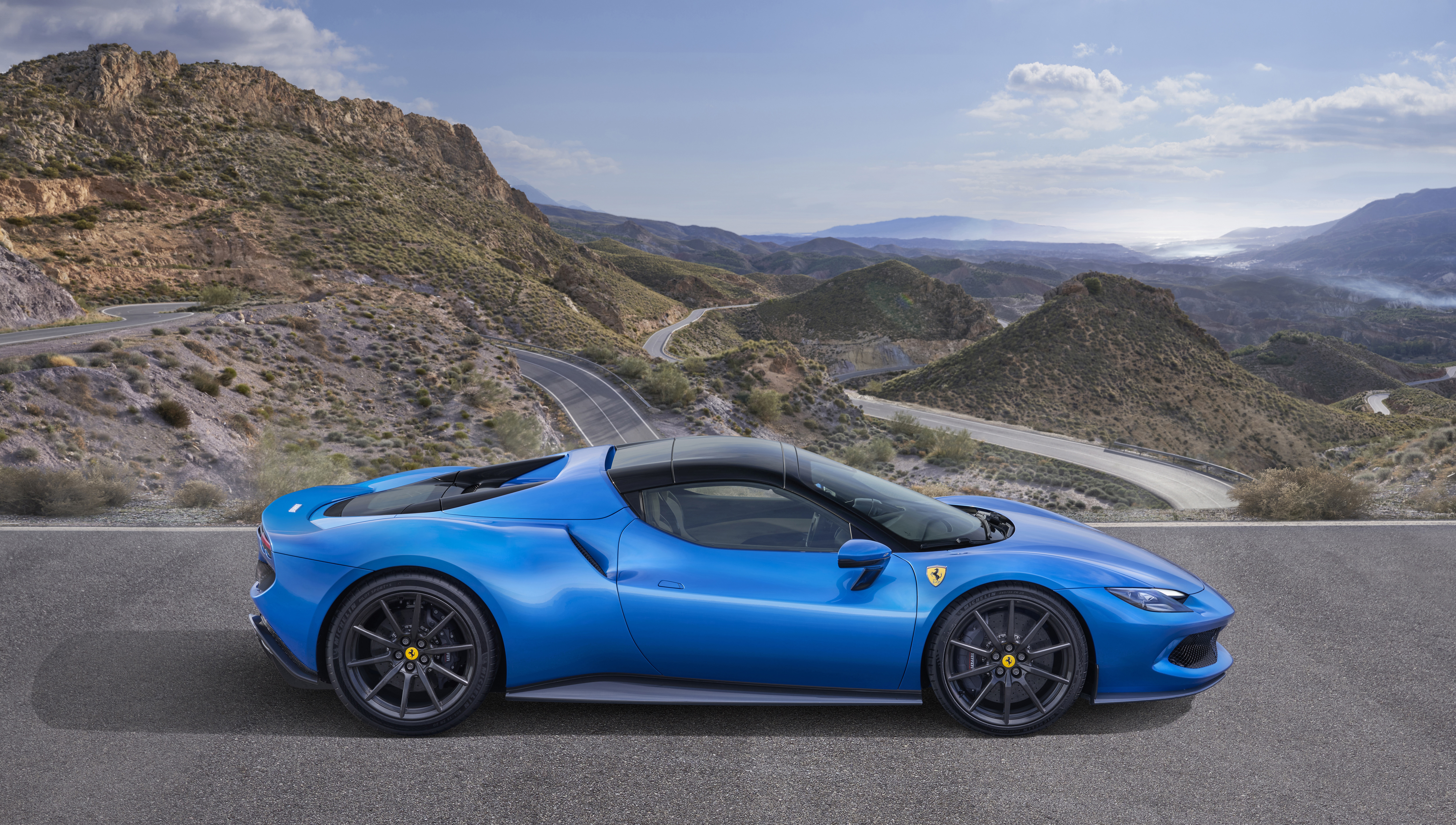 Blue Ferrari 296 GTS on a mountain road HD Wallpaper