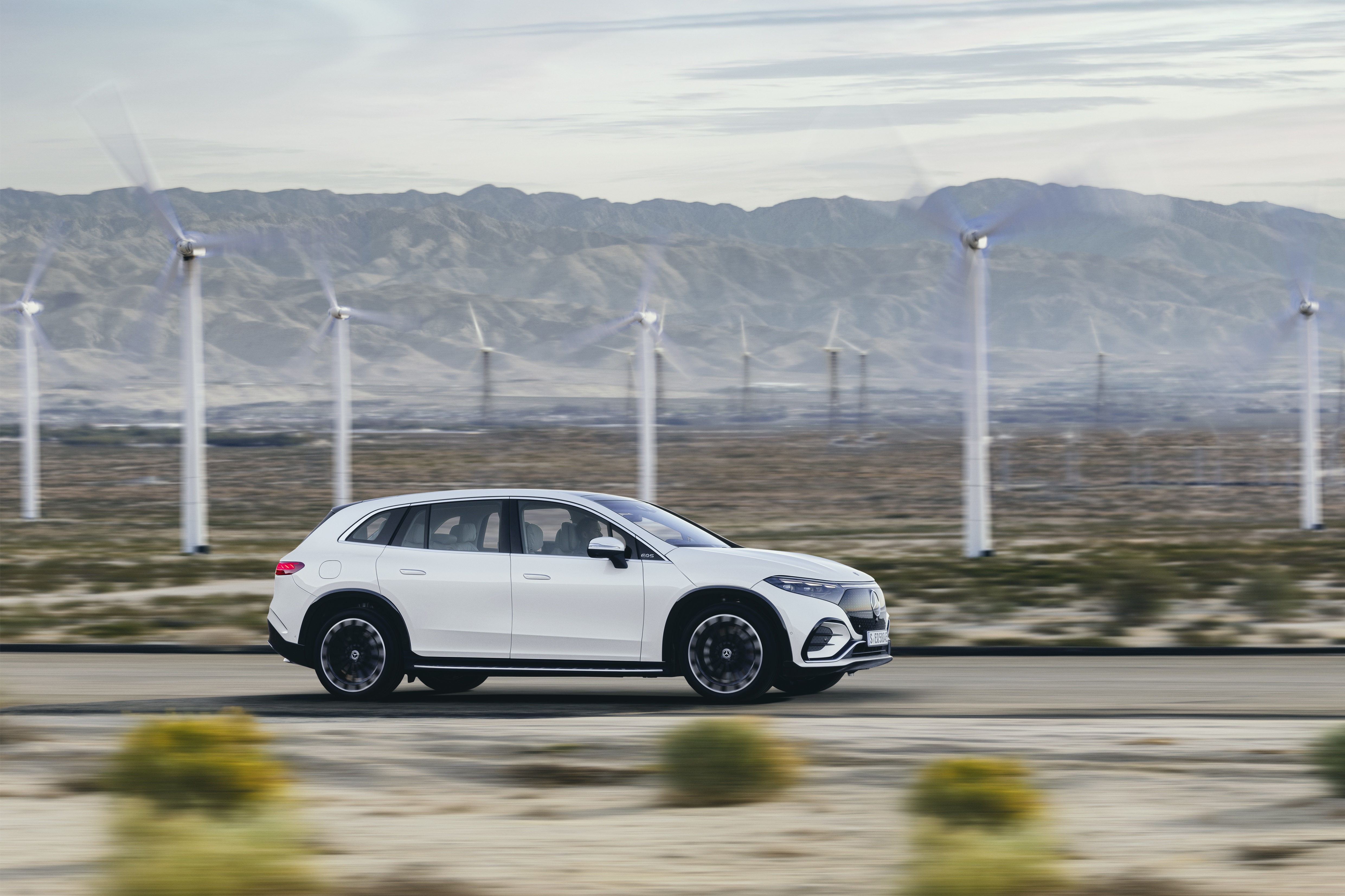 White Mercedes-Benz EQS 450+ 4K driving near wind turbines HD Wallpaper