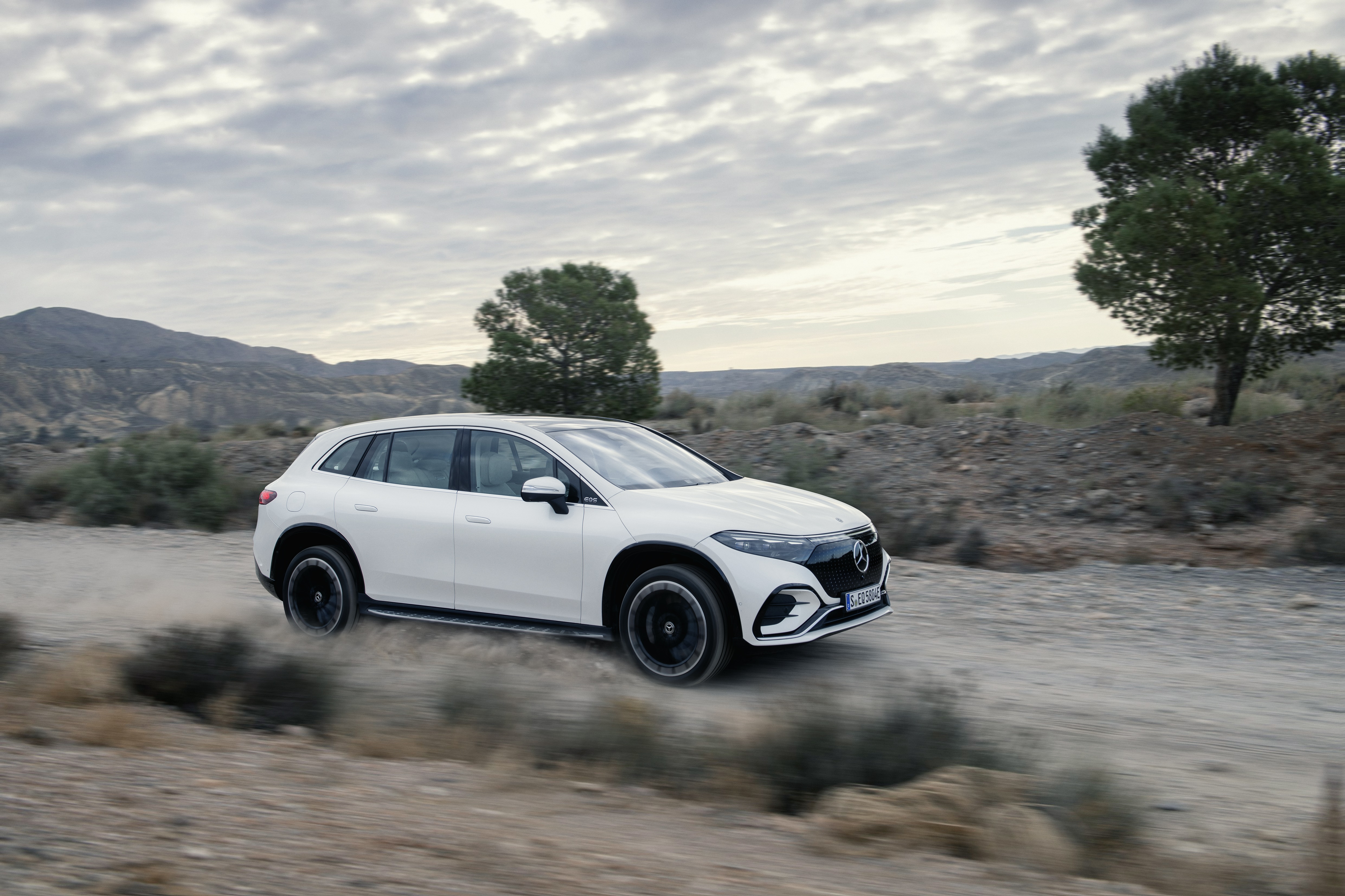 White Mercedes-Benz EQS 450+ 4K driving on dirt road HD Wallpaper