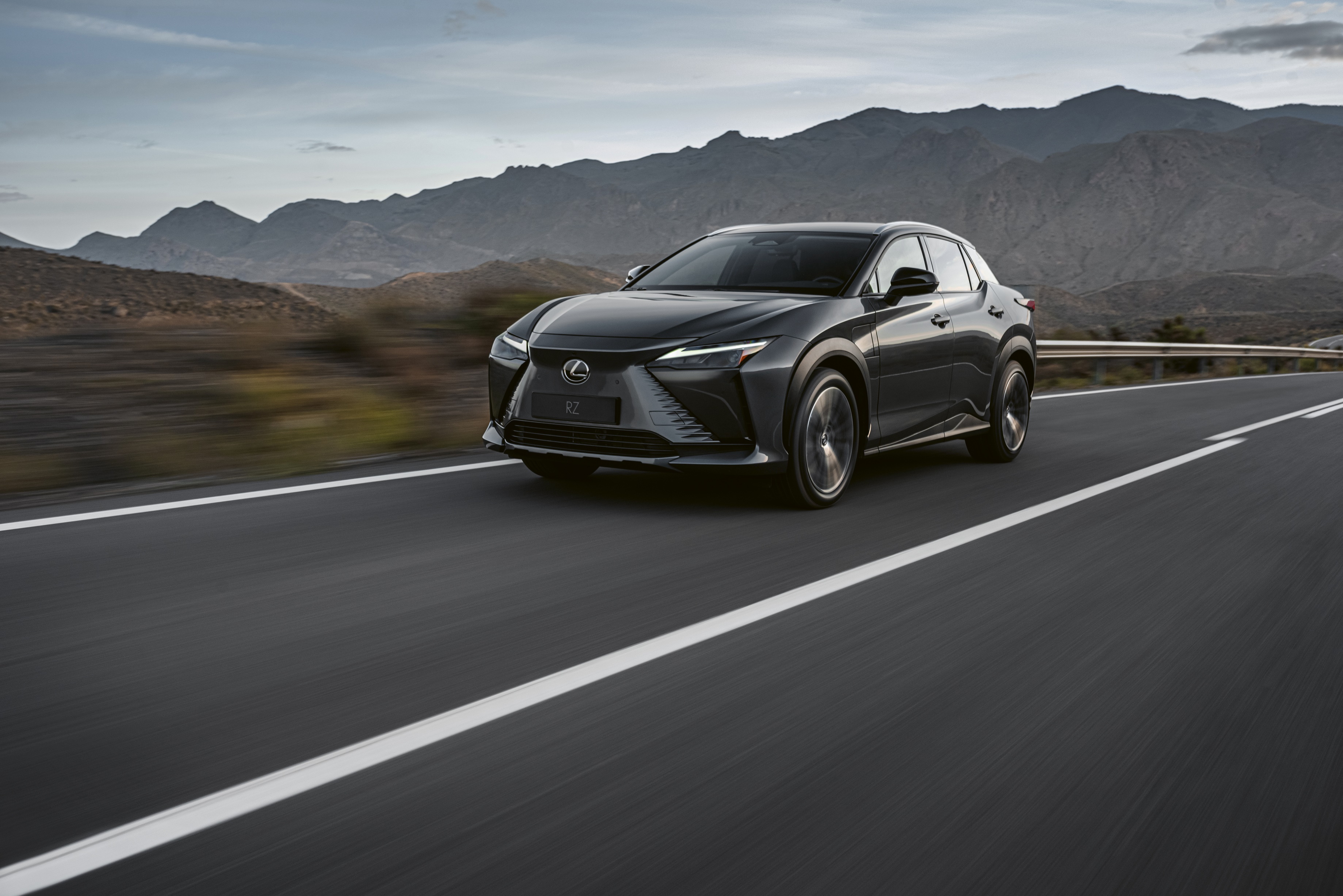 Lexus RZ 450e driving on a road HD Wallpaper