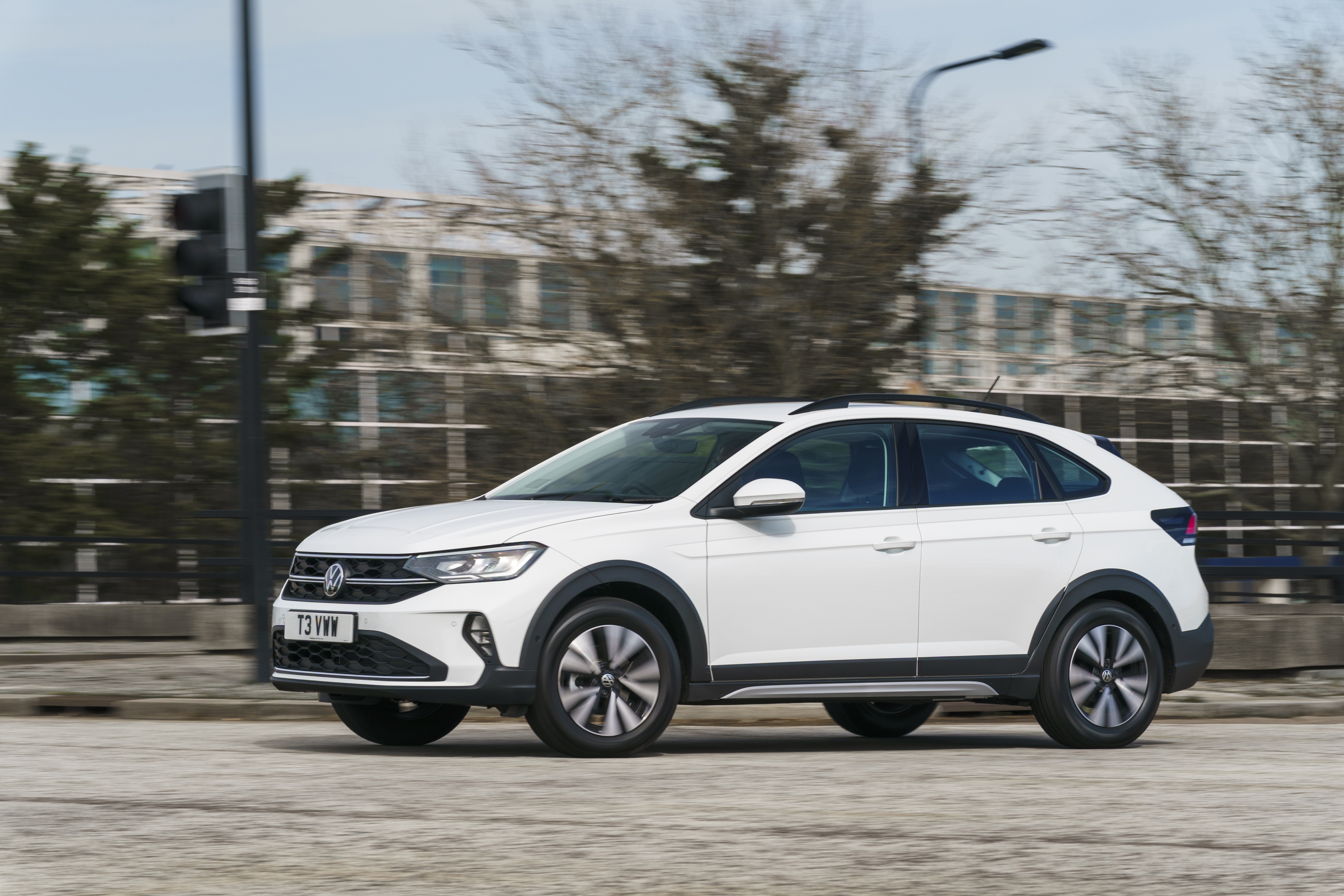 White Volkswagen Taigo driving on a road HD Wallpaper