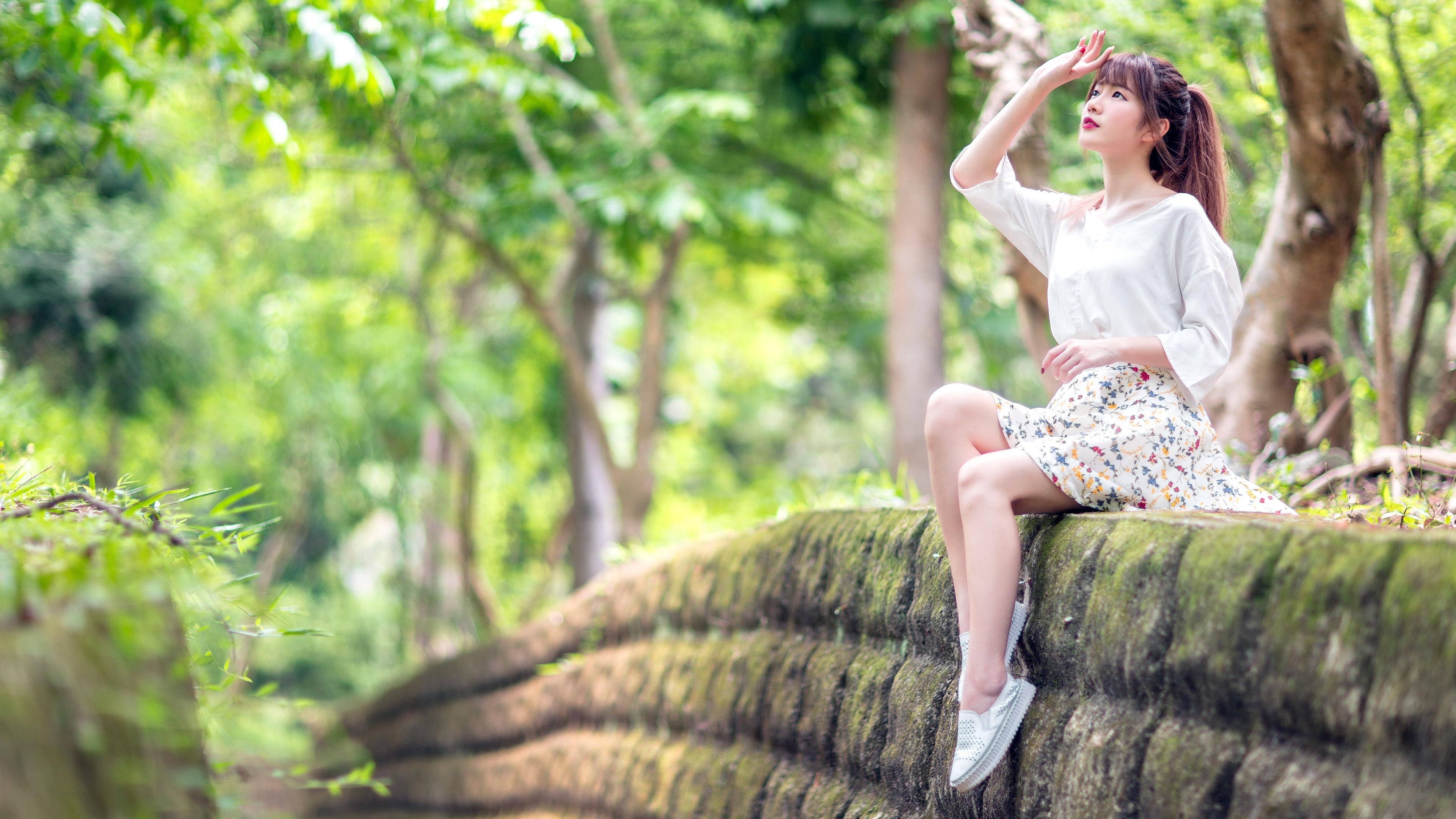 Asian Woman Sitting on Mossy Stone Wall in HD Wallpaper