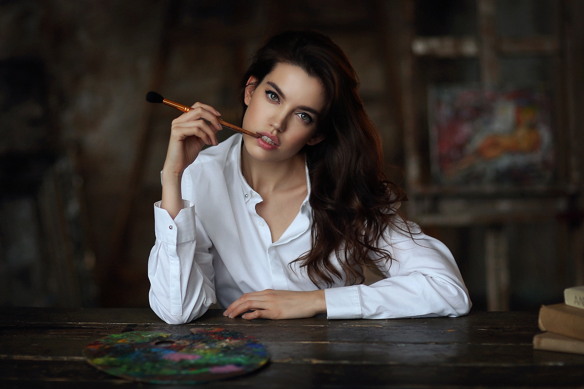 Woman holding paintbrush in studio HD Wallpaper