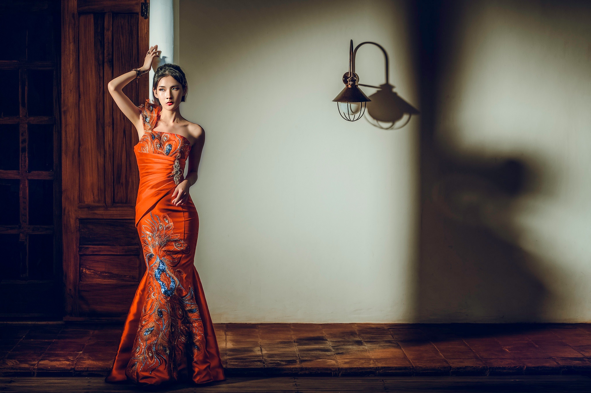 Woman in orange dress with peacock design HD Wallpaper